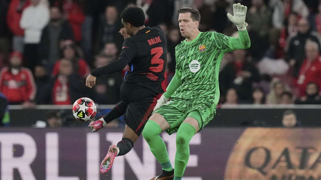 Barcelona's Alejandro Balde collides with Barcelona's goalkeeper Wojciech Szczęsny during a Champions League opening phase soccer match between SL Benfica and FC Barcelona at the Luz stadium in Lisbon, Tuesday, Jan. 21, 2025.