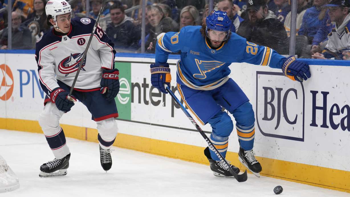 Columbus Blue Jackets' Luca Del Bel Belluz (65) and St. Louis Blues' Brandon Saad (20) chase after a loose puck during the second period of an NHL hockey game Saturday, Jan. 11, 2025, in St. Louis.