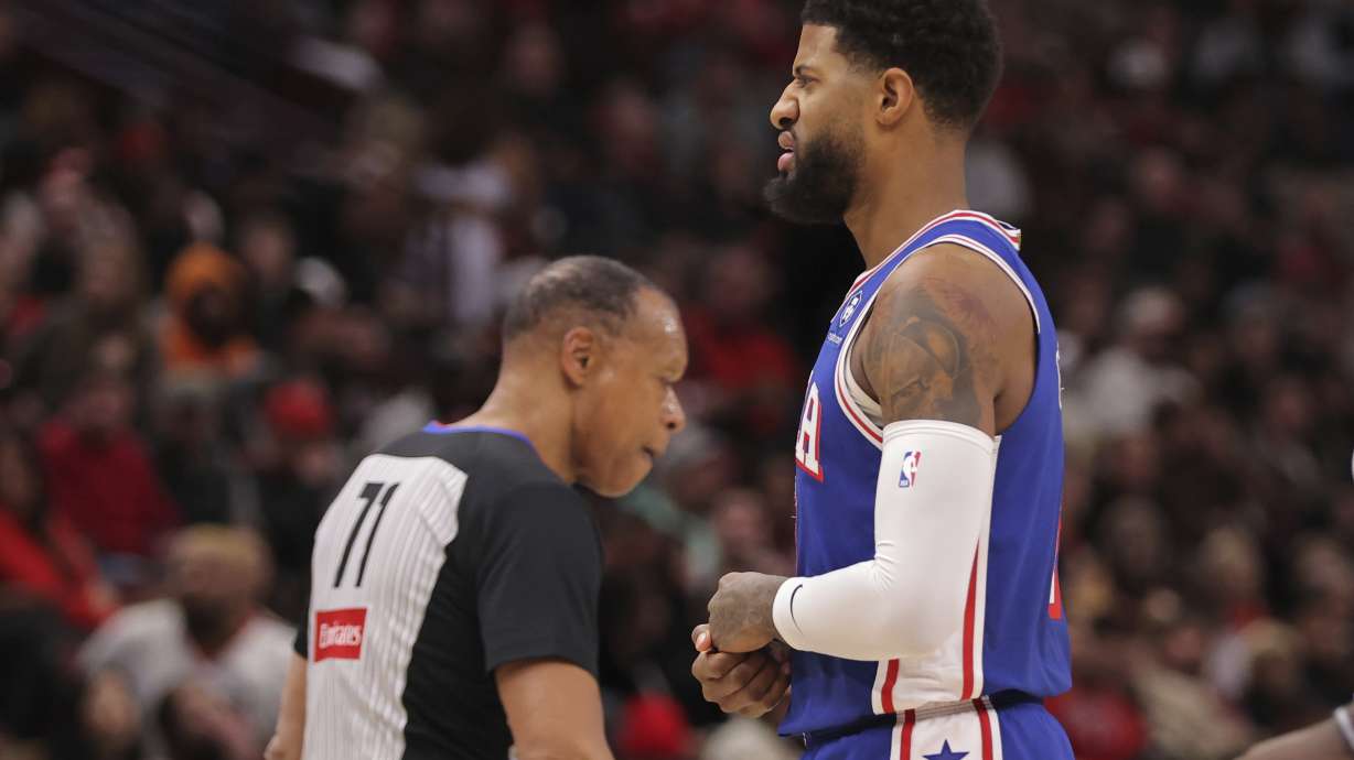 Philadelphia 76ers forward Paul George grabs his hand as he walks back to the bench during the first half of an NBA basketball game against the Chicago Bulls, Saturday, Jan. 25, 2025, in Chicago.