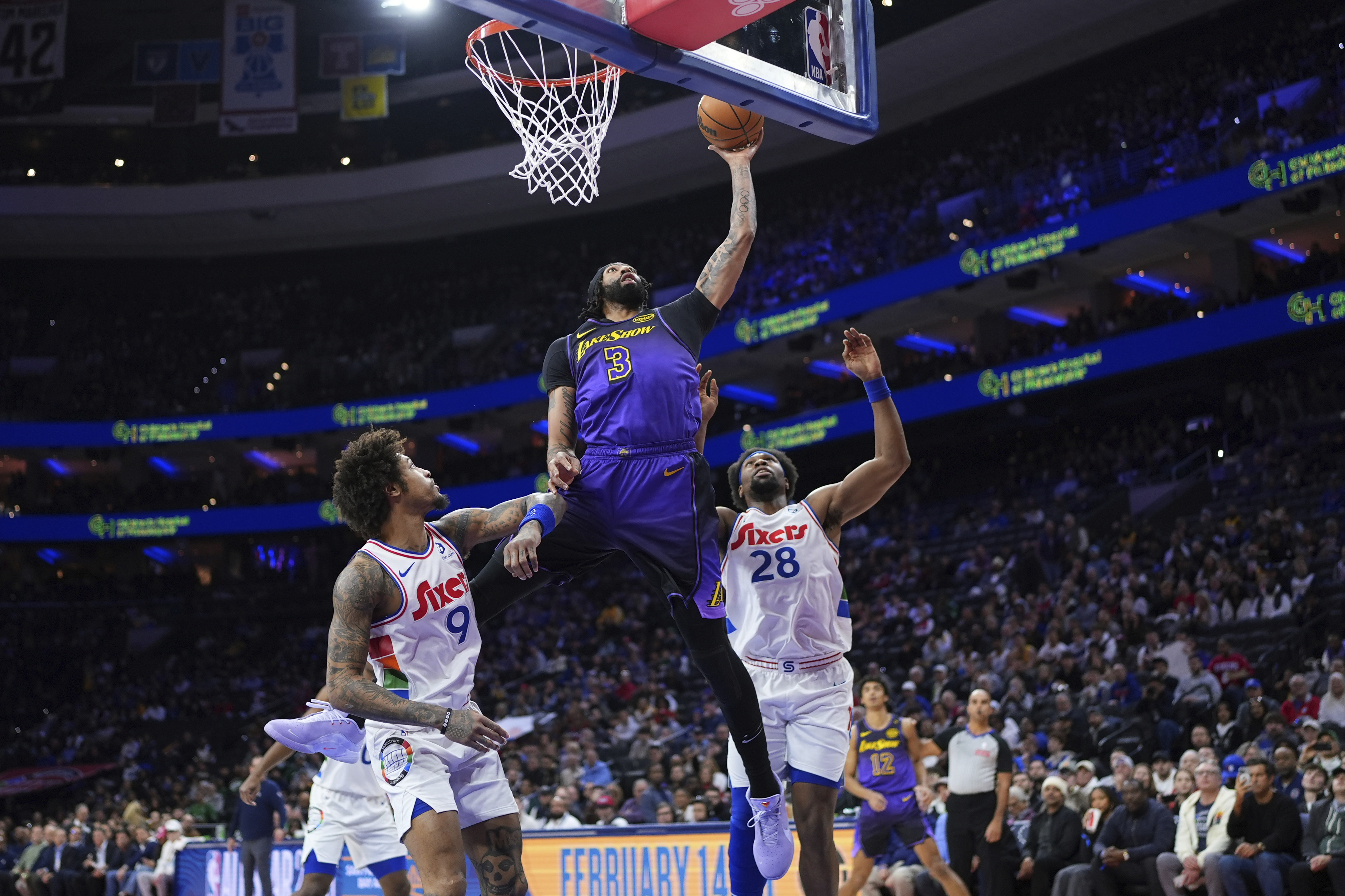Los Angeles Lakers' Anthony Davis (3) goes up for a shot against Philadelphia 76ers' Guerschon Yabusele (28) and Kelly Oubre Jr. (9) during the first half of an NBA basketball game, Tuesday, Jan. 28, 2025, in Philadelphia. 