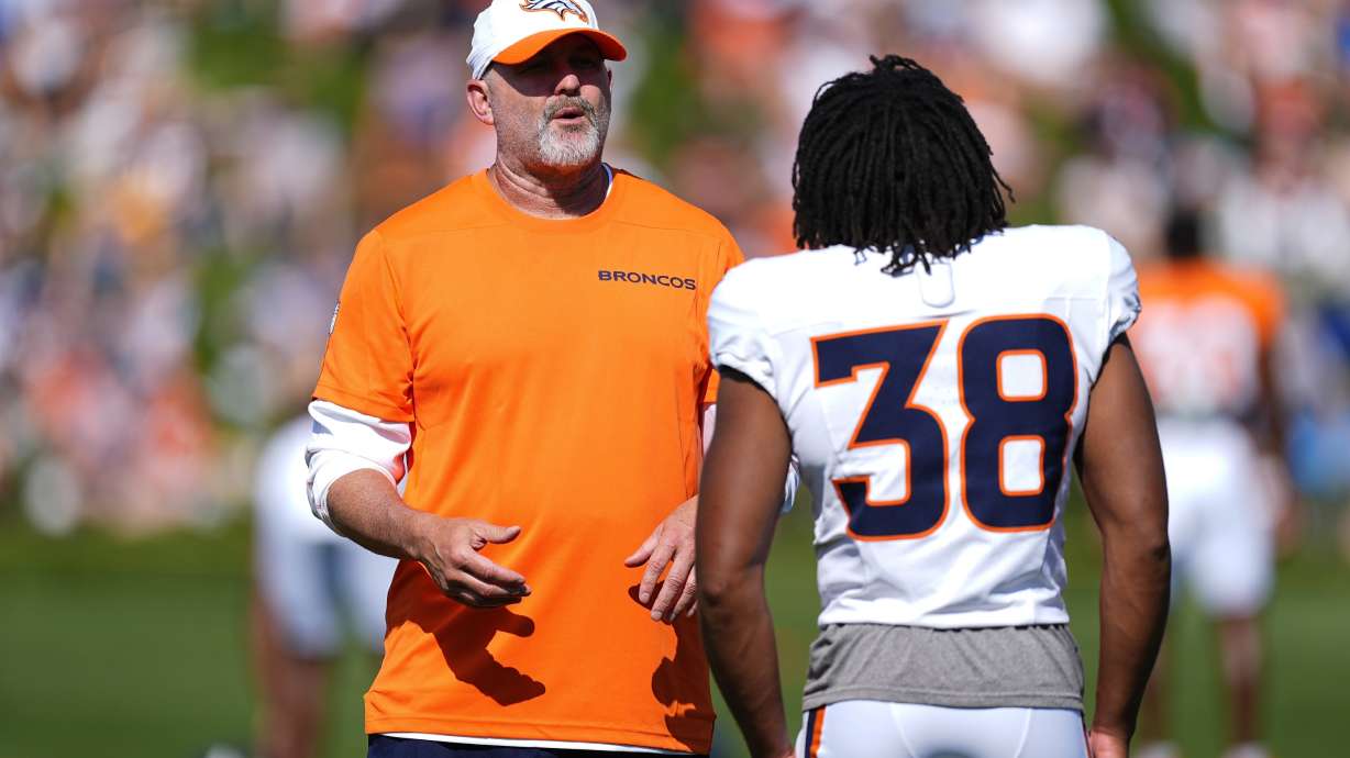 FILE - Denver Broncos pass game coordinator John Morton, left, chats with running back Jaleel McLaughlin as he takes part in drills at an NFL football training camp Wednesday, July 31, 2024, at the team's headquarters in Centennial, Colo.