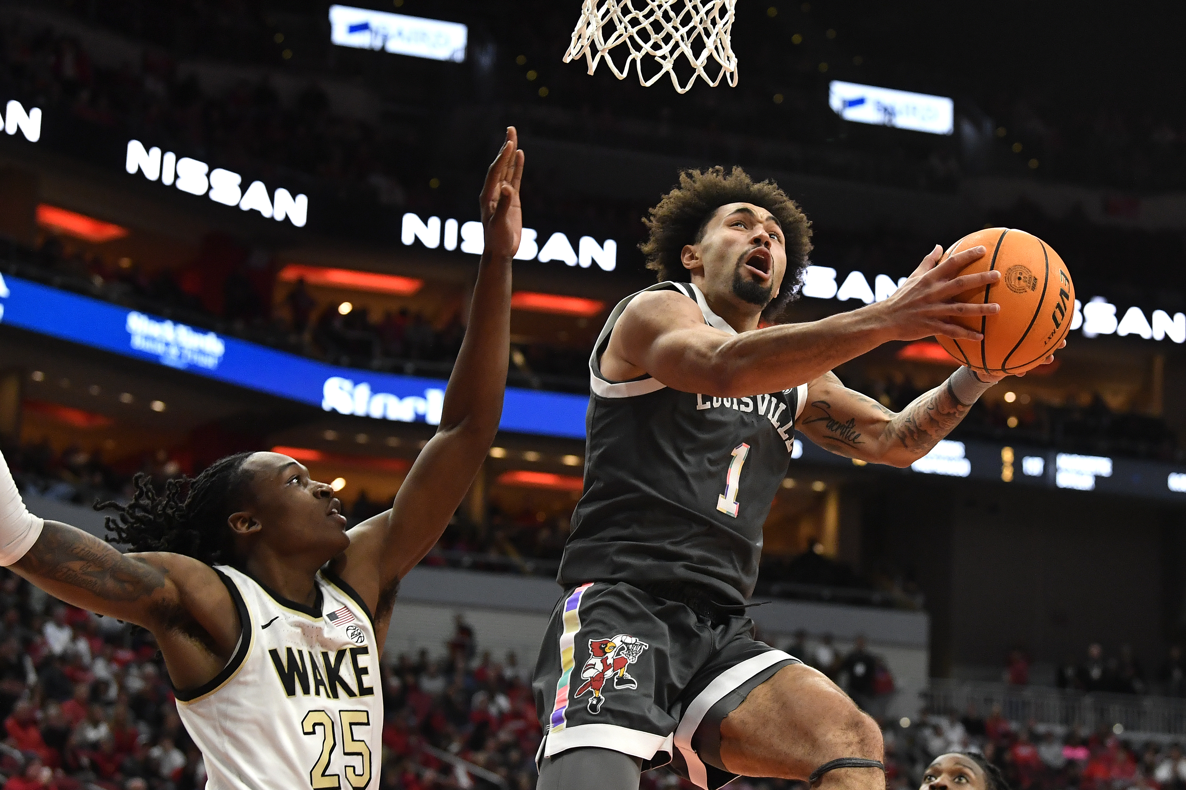 Louisville guard J'Vonne Hadley (1) goes up for a layup over Wake Forest forward Tre'Von Spillers (25) during the second half of an NCAA college basketball game in Louisville, Ky., Tuesday, Jan. 28, 2025. 