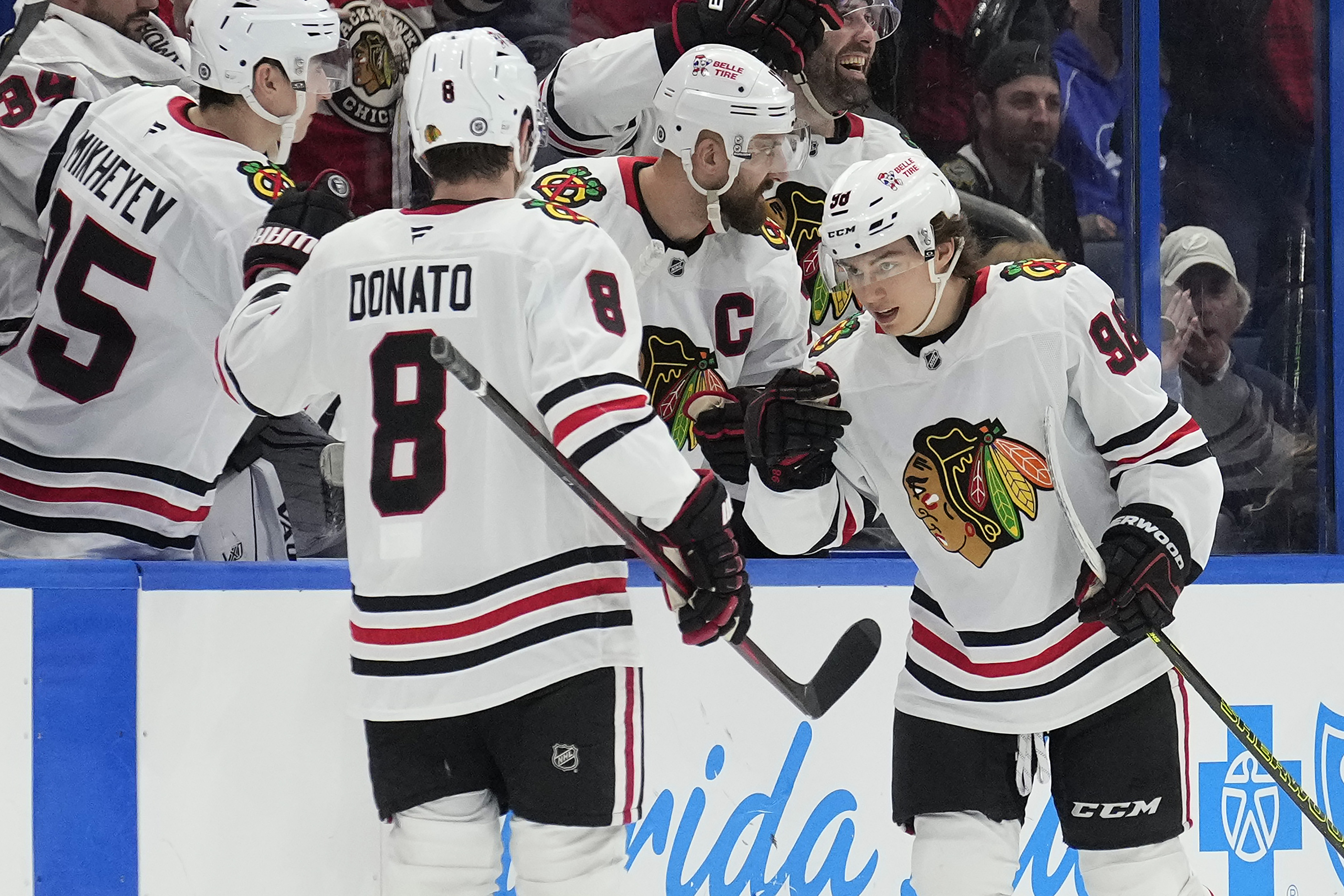 Chicago Blackhawks center Connor Bedard (98) celebrates his goal against the Tampa Bay Lightning with center Ryan Donato (8) during the second period of an NHL hockey game Tuesday, Jan. 28, 2025, in Tampa, Fla.