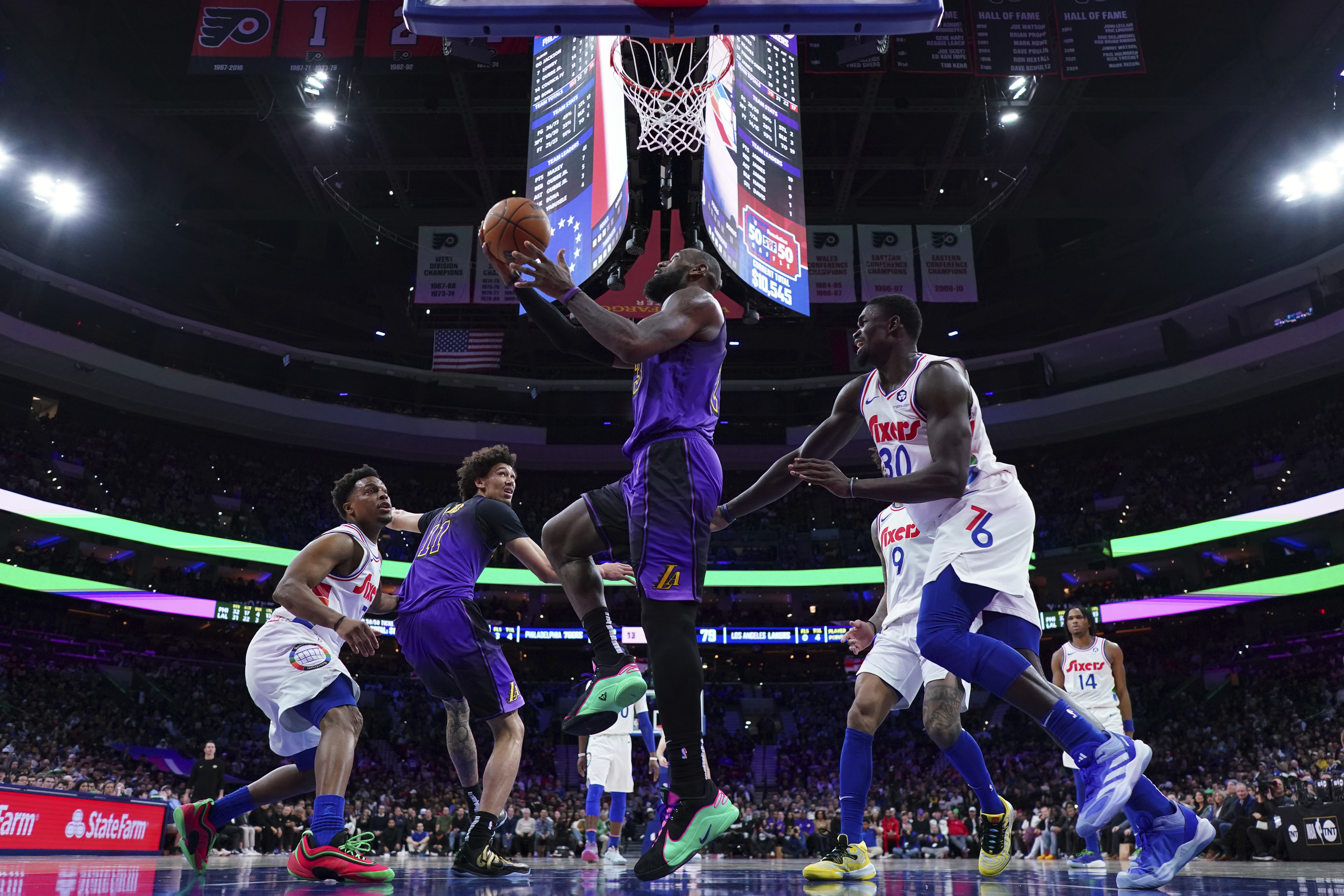 Los Angeles Lakers' LeBron James, center, goes up for a shot past Philadelphia 76ers' Adem Bona during the second half of an NBA basketball game, Tuesday, Jan. 28, 2025, in Philadelphia. 