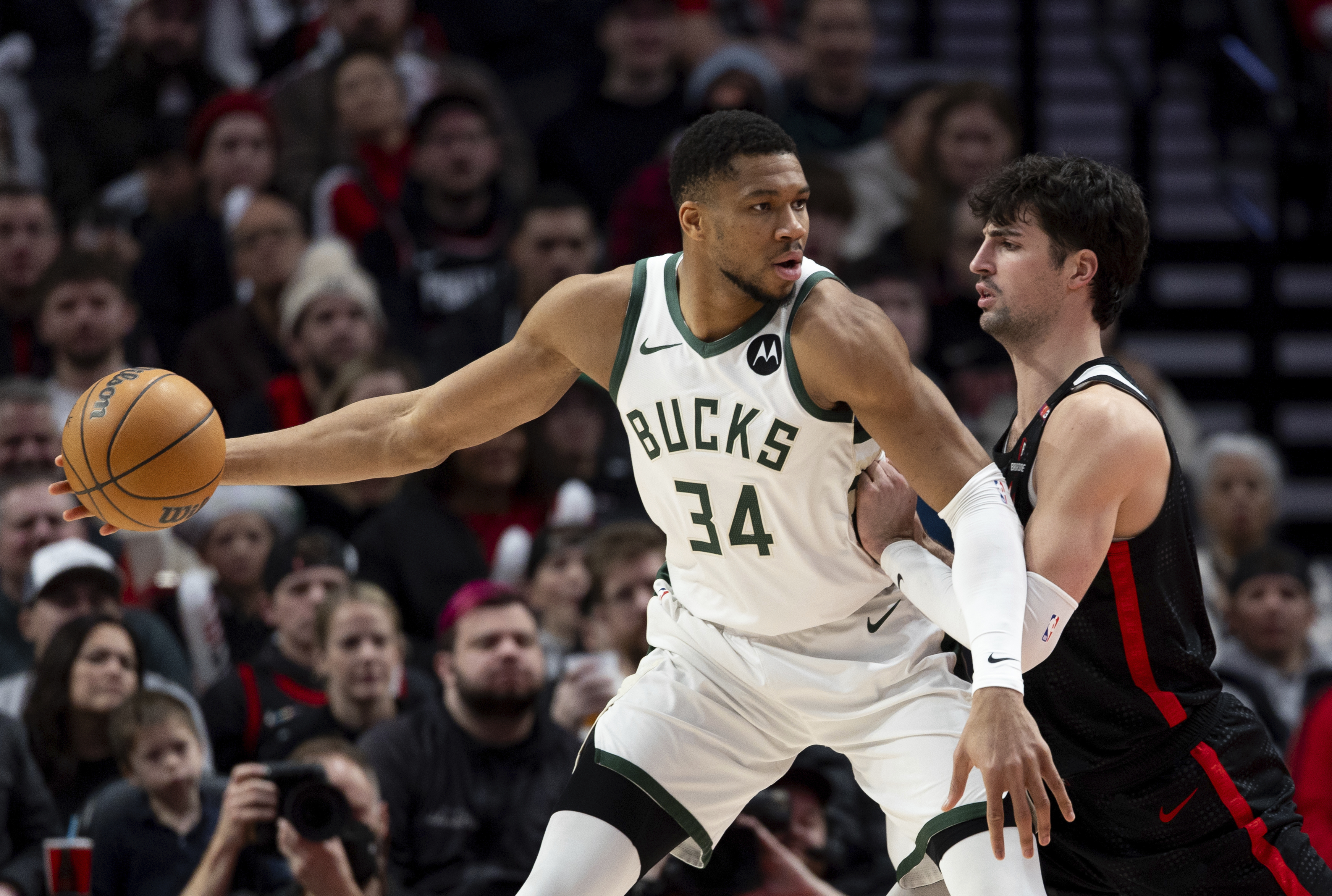 Milwaukee Bucks forward Giannis Antetokounmpo, left, dribbles the ball against Portland Trail Blazers forward Deni Avdija, right, during the second half of an NBA basketball game Tuesday, Jan. 28, 2025, in Portland, Ore.