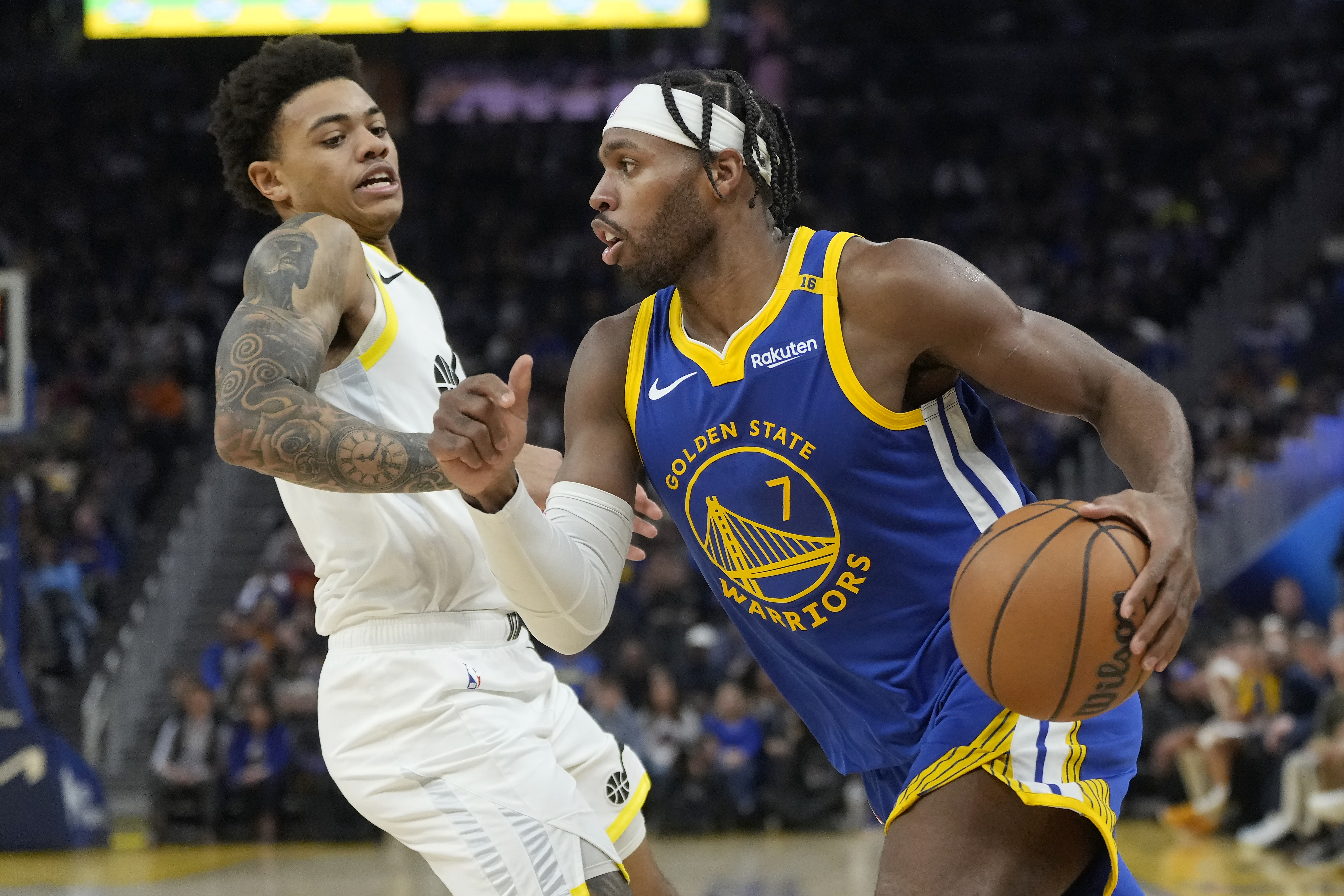 Golden State Warriors guard Buddy Hield (7) drives to the basket against Utah Jazz guard Keyonte George during the first half of an NBA basketball game in San Francisco, Tuesday, Jan. 28, 2025. 