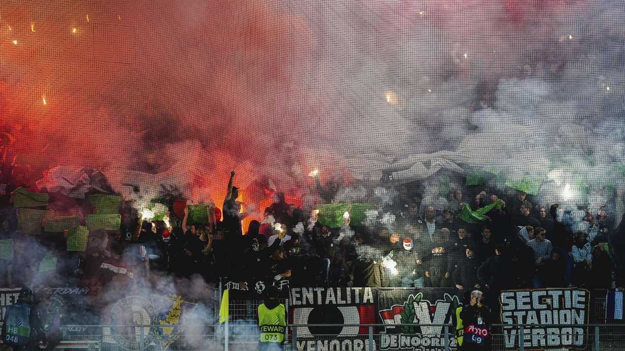 FILE - Fans of Feyenoord light flares during the Europa League Group F soccer match between Sturm Graz and Feyenoord at the Merkur Arena in Graz, Austria, Thursday, Oct. 27, 2022.