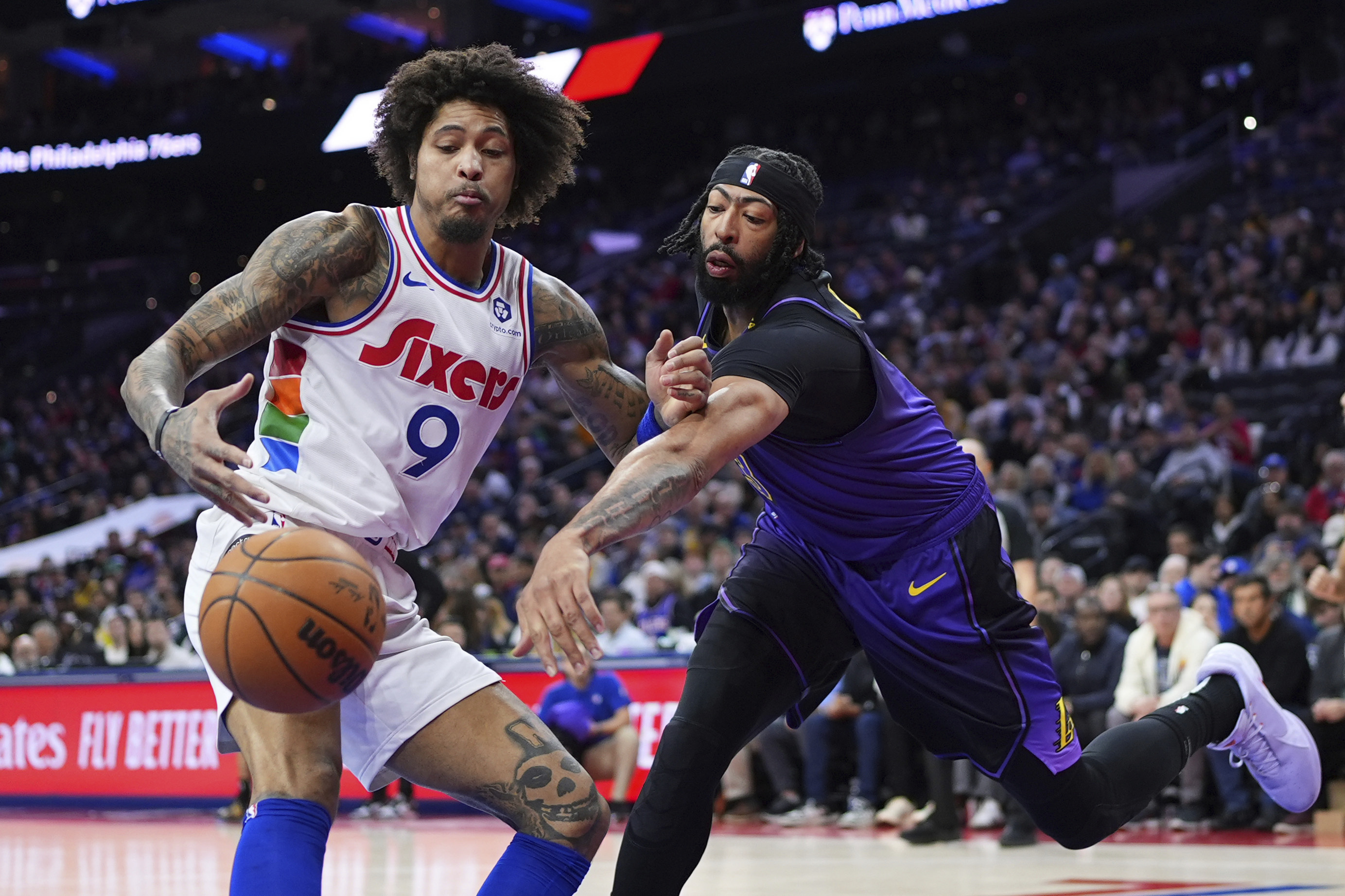 Los Angeles Lakers' Anthony Davis, right, and Philadelphia 76ers' Kelly Oubre Jr. battle for a loose ball during the first half of an NBA basketball game, Tuesday, Jan. 28, 2025, in Philadelphia. 