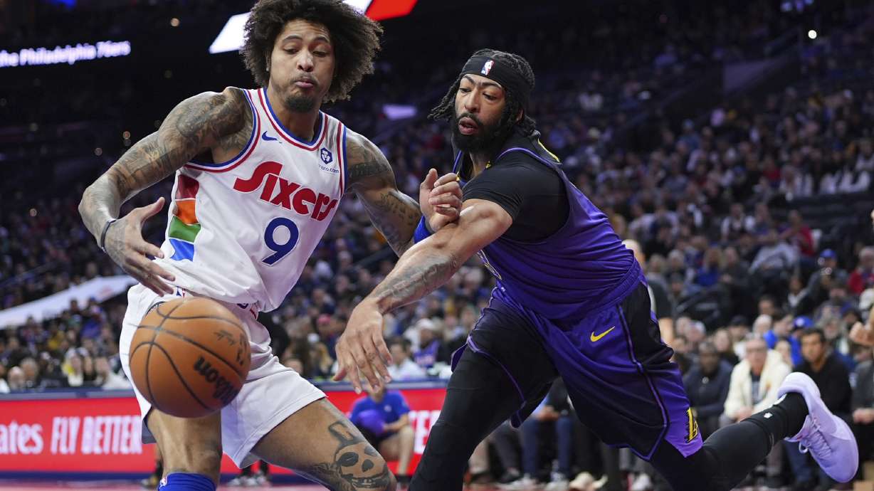 Los Angeles Lakers' Anthony Davis, right, and Philadelphia 76ers' Kelly Oubre Jr. battle for a loose ball during the first half of an NBA basketball game, Tuesday, Jan. 28, 2025, in Philadelphia.
