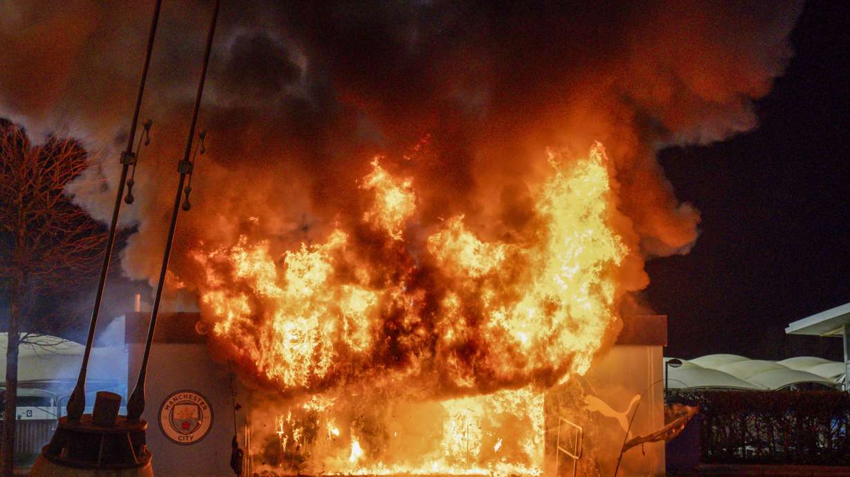 A fire burns at a merchandise kiosk outside the Etihad Stadium stadium before the Champions League opening phase soccer match between Manchester City and Brugge in Manchester, England, Wednesday, Jan. 29, 2025.