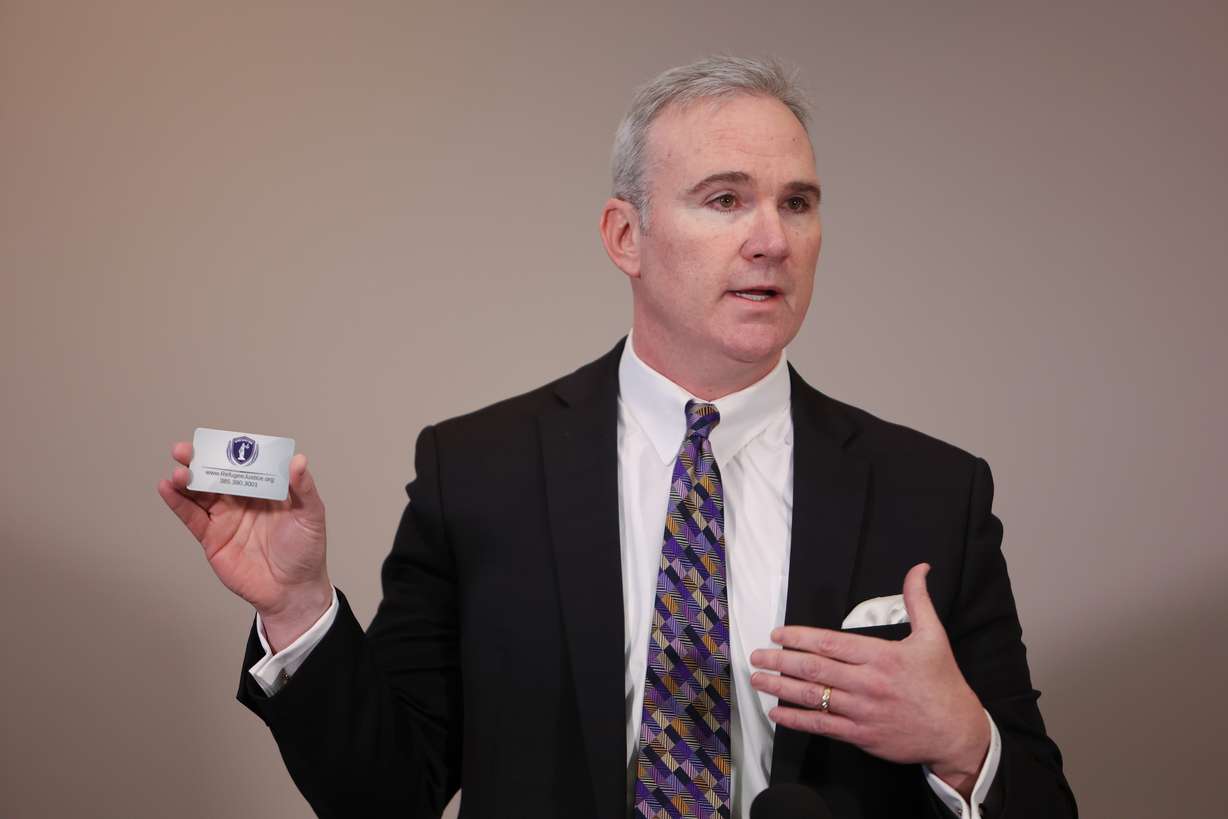 Norm McKellar, Refugee Justice League executive director, holds a rights card at a press conference at the Utah State Bar office in Salt Lake City on Wednesday.