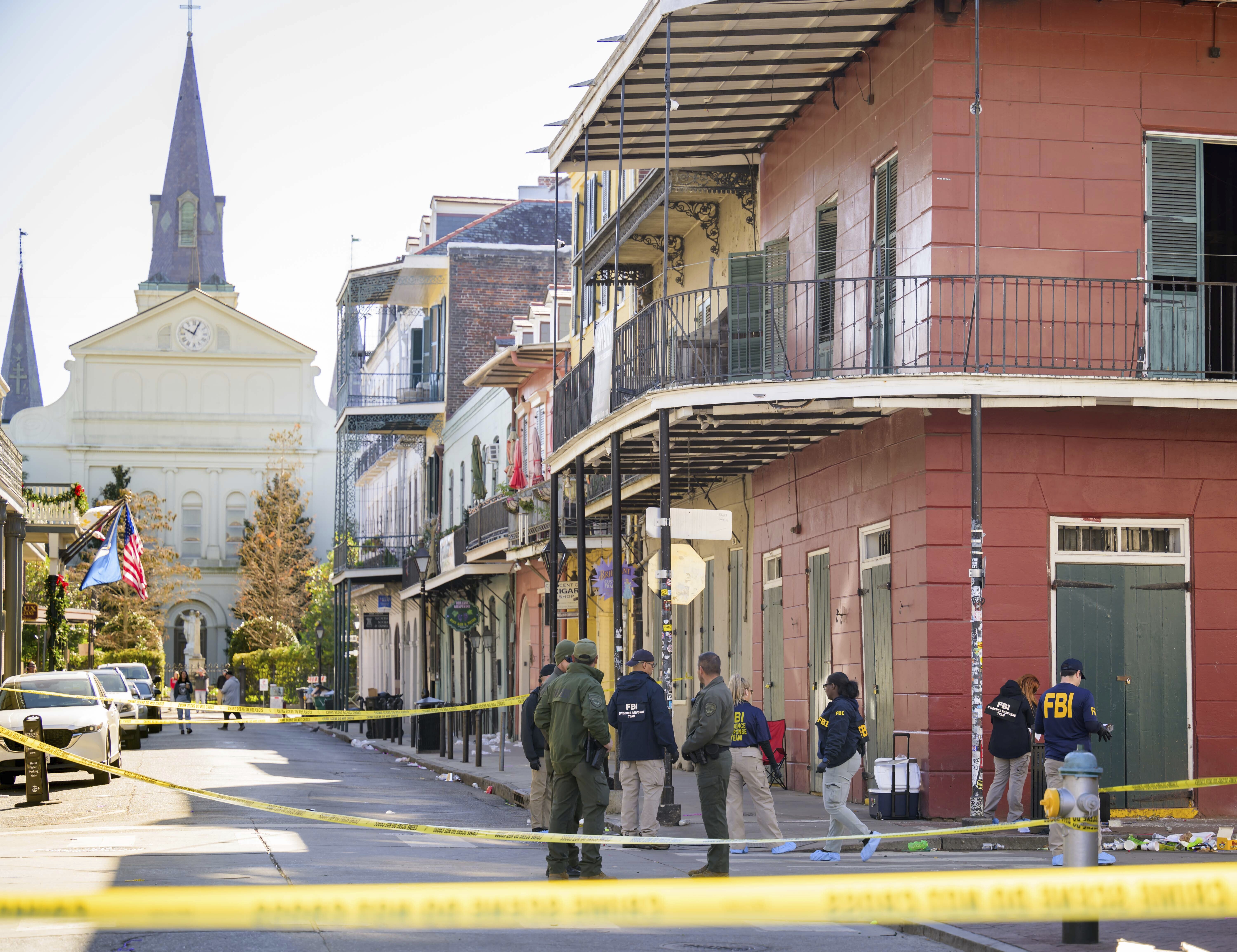 Members of the FBI work on Orleans Street and Bourbon Street by St. Louis Cathedral in the French Quarter near where a suspicious package was detonated during the investigation of a truck crashing into pedestrians on Bourbon Street Wednesday, Jan. 1, 2025. The suspect was also seen leaving the rolling cooler by the corner of the red building which contained the package that was previously detonated.