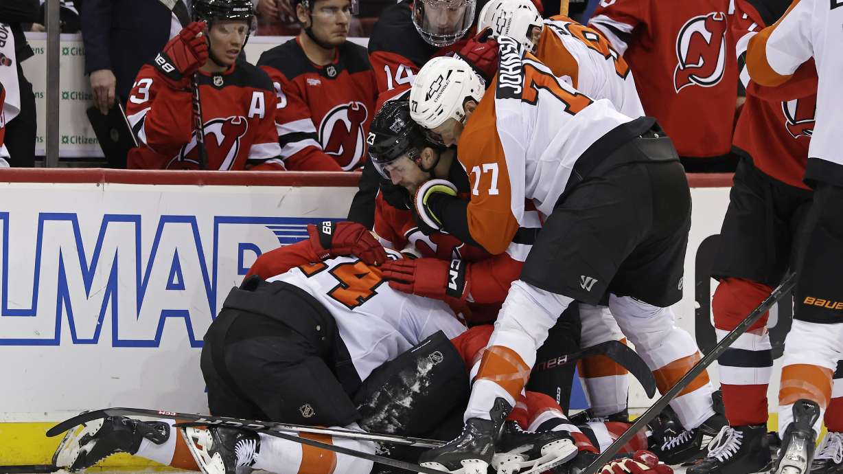 Philadelphia Flyers defenseman Erik Johnson (77) tries pulling New Jersey Devils left wing Kurtis MacDermid away from a scuffle during the second period of an NHL hockey game, Wednesday, Jan. 29, 2025, in Newark, N.J.