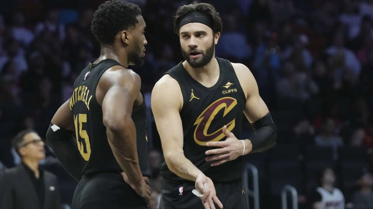 Cleveland Cavaliers guard Donovan Mitchell talks with guard Max Strus, right, during the first half of an NBA basketball game against the Miami Heat, Wednesday, Jan. 29, 2025, in Miami.