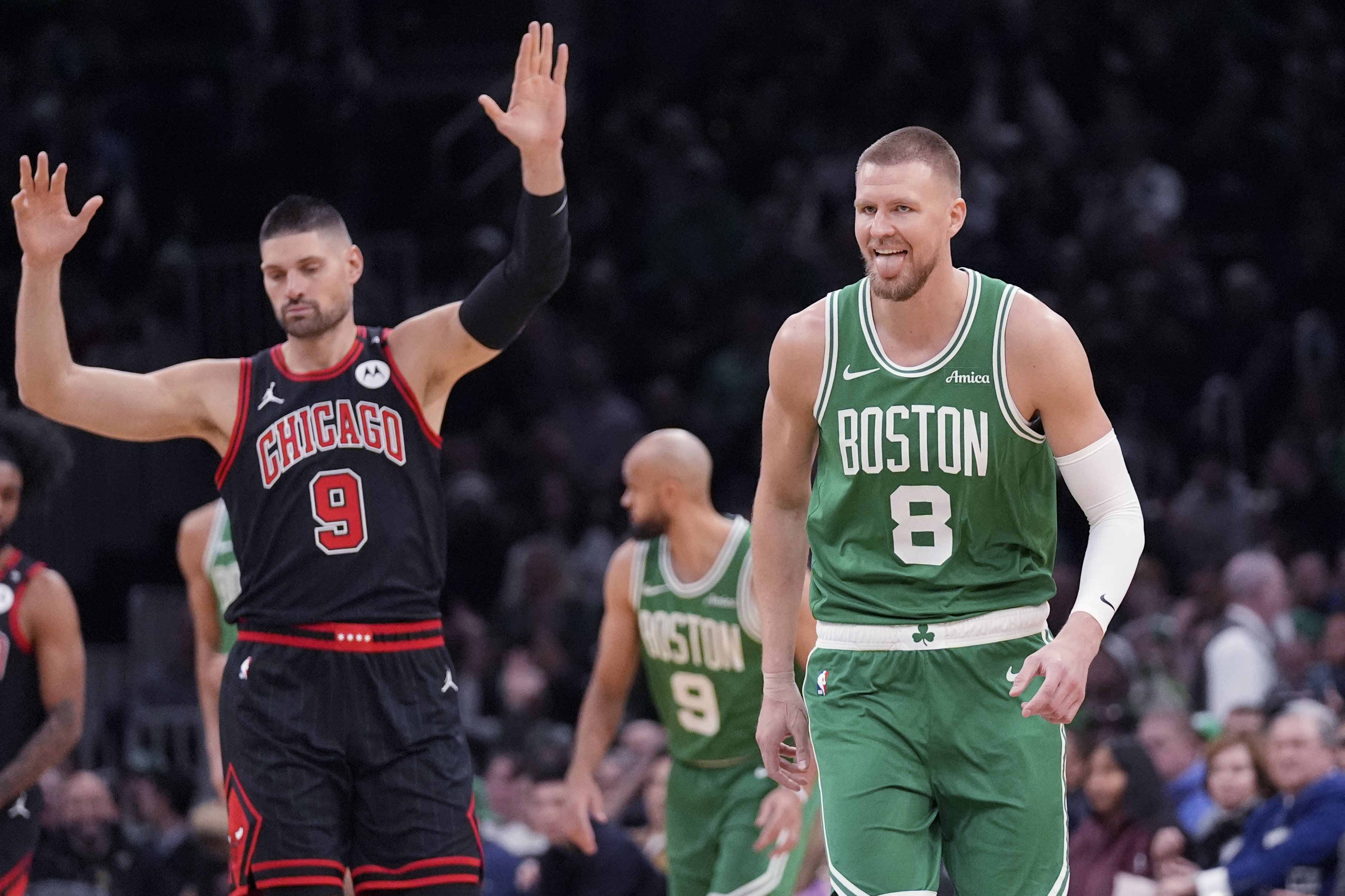 Boston Celtics center Kristaps Porzingis (8) reacts after hitting a 3-pointer against Chicago Bulls center Nikola Vucevic (9) during the first half of an NBA basketball game, Wednesday, Jan. 29, 2025, in Boston.