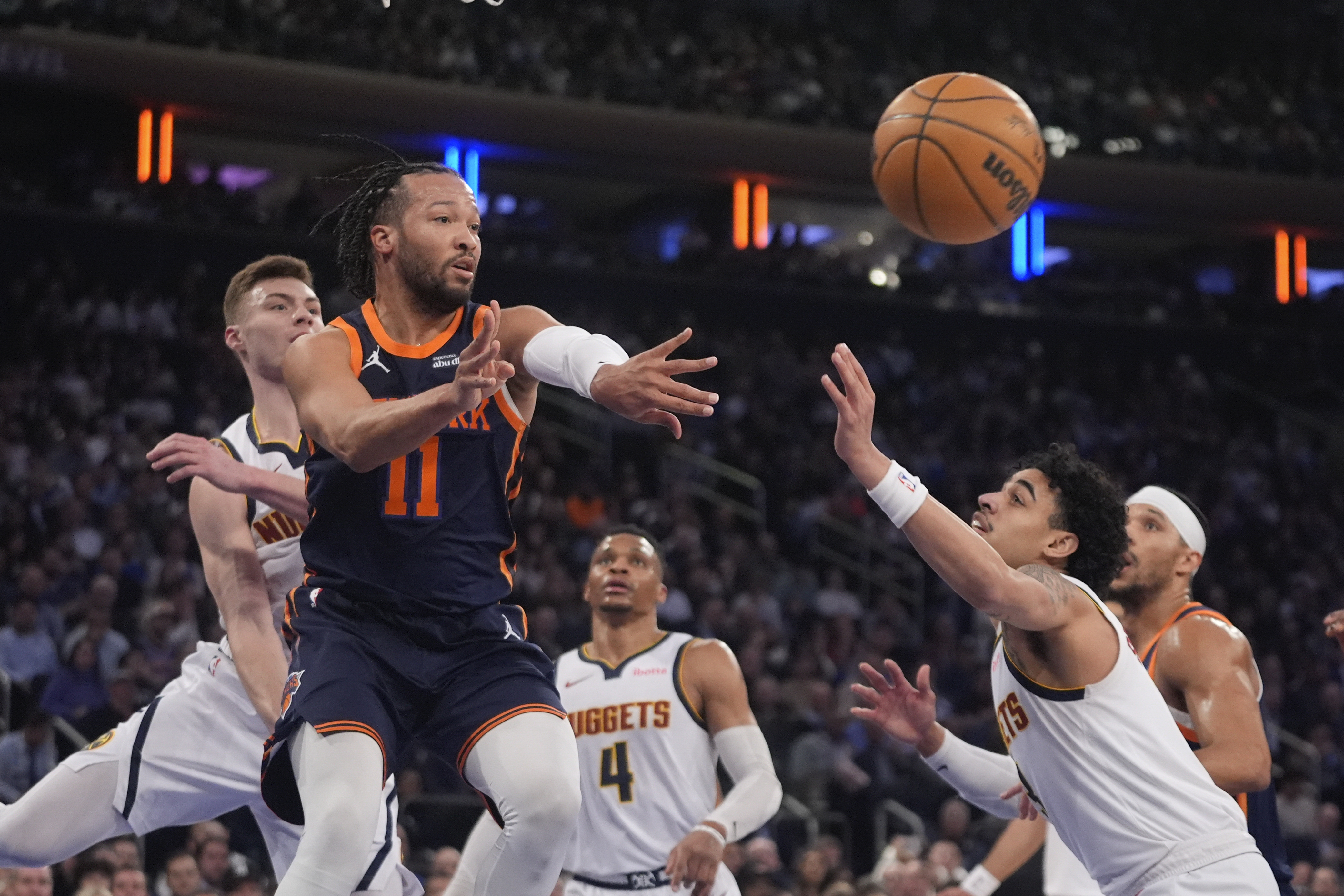 New York Knicks' Jalen Brunson, center, passes away from Denver Nuggets' Christian Braun, left, and Julian Strawther during the first half of an NBA basketball game Wednesday, Jan. 29, 2025, in New York. 