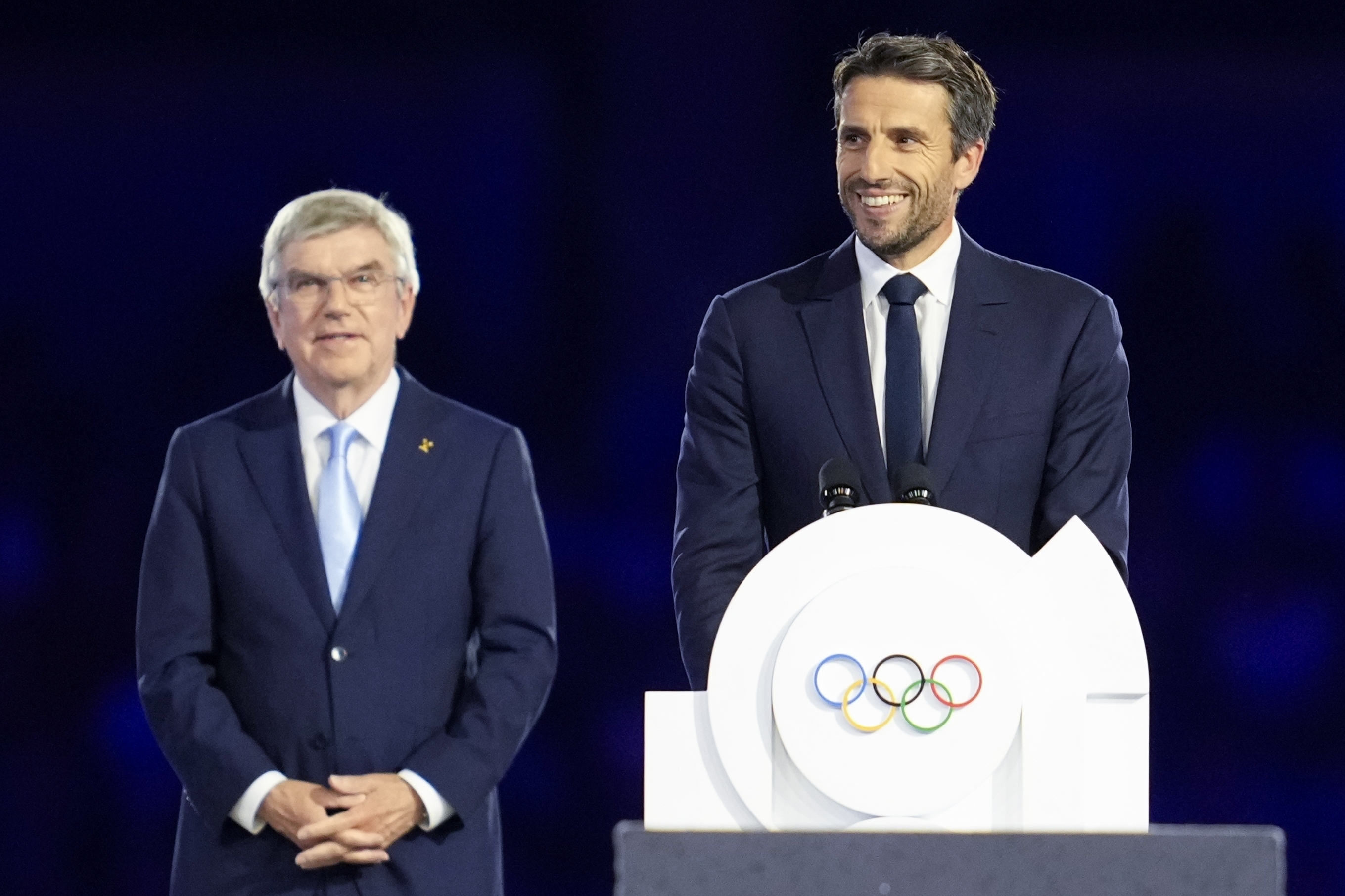 FILE - The President of the Paris 2024 Organizing Committee, Tony Estanguet, right, addresses the audience as IOC President Thomas Bach, left, watches during the 2024 Summer Olympics closing ceremony at the Stade de France, Sunday, Aug. 11, 2024, in Saint-Denis, France.