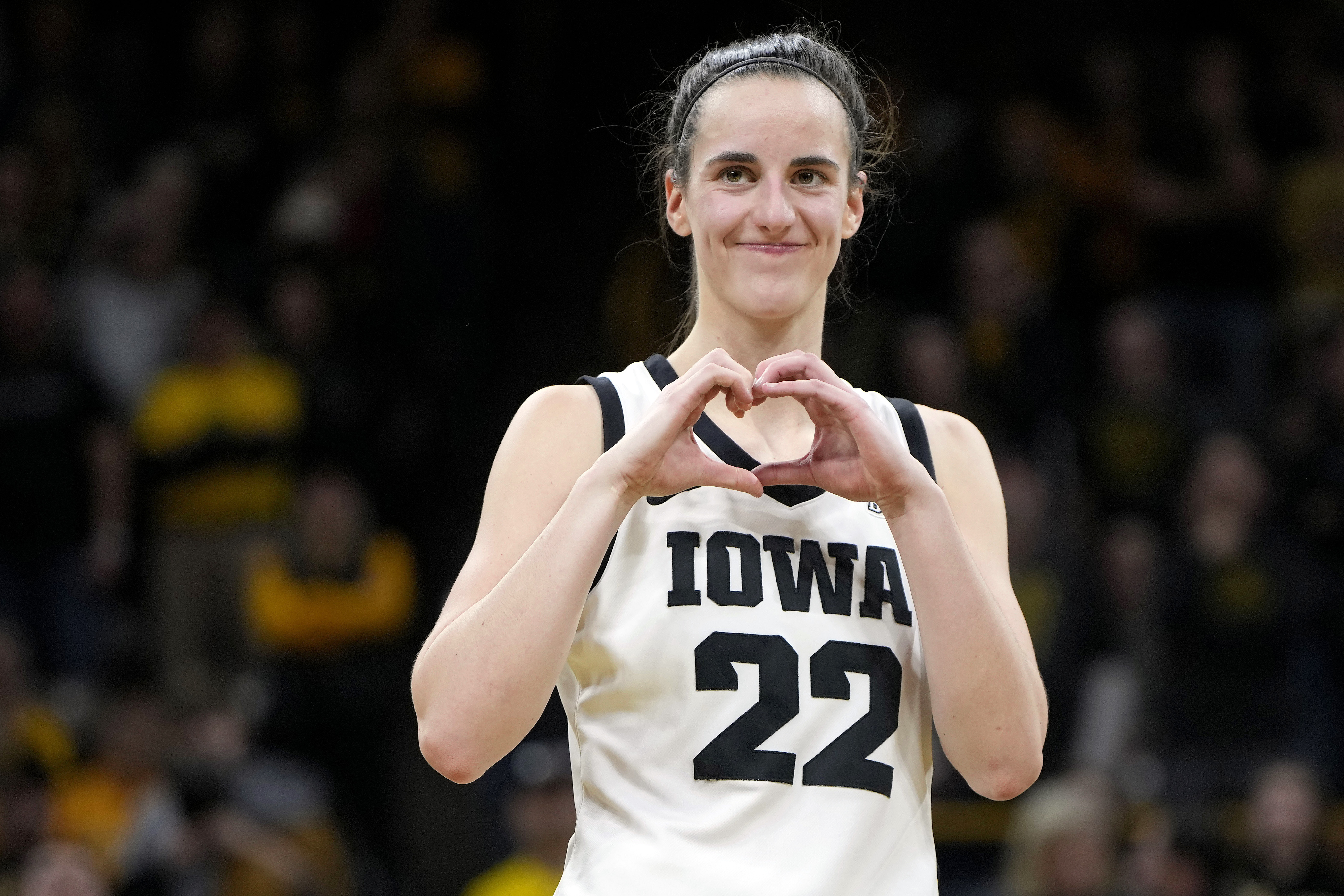 FILE - Iowa guard Caitlin Clark makes a heart gesture after the team's NCAA college basketball game against Michigan, Thursday, Feb. 15, 2024, in Iowa City, Iowa. Clark broke the NCAA women's career scoring record. 