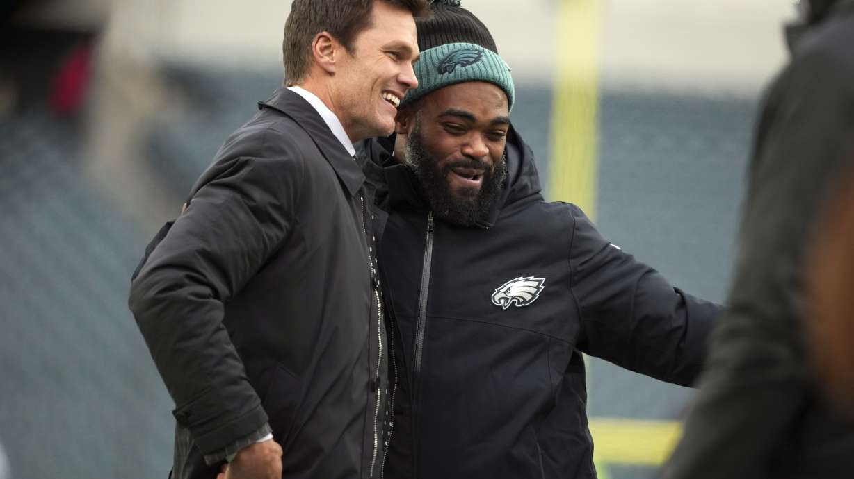 FILE - Former quarterback Tom Brady, left, jokes with Philadelphia Eagles defensive end Brandon Graham before an NFL football game against the Pittsburgh Steelers on Sunday, Dec. 15, 2024, in Philadelphia.