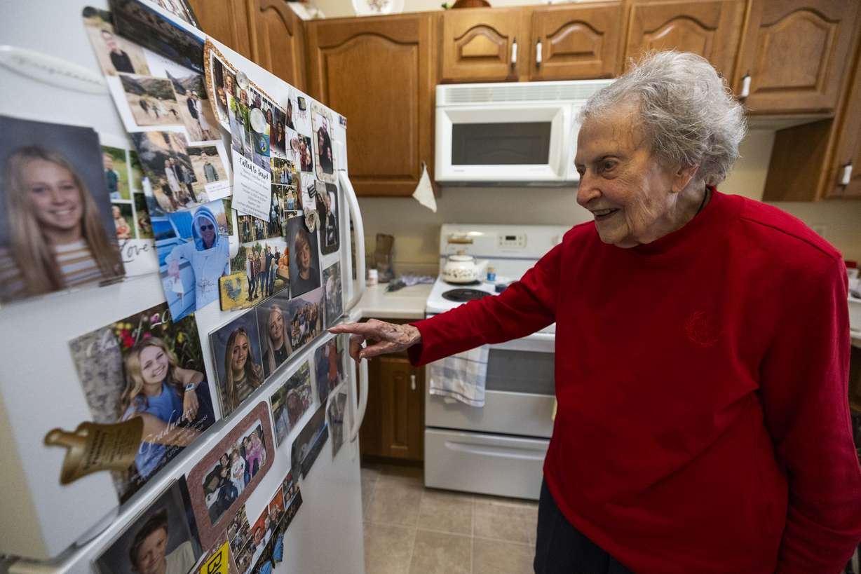 Donna Norton, soon to be 104 years old, points to pictures of her 10 grandchildren and 14 great-grandchildren while talking about them in the kitchen of her apartment in the Escalante at Coventry Senior Living facility in Cottonwood Heights on Wednesday. Despite her age, Norton lives in an area for residents who are independent, where she regularly takes out her own trash, goes on walks and keeps up with her friends around the facility.