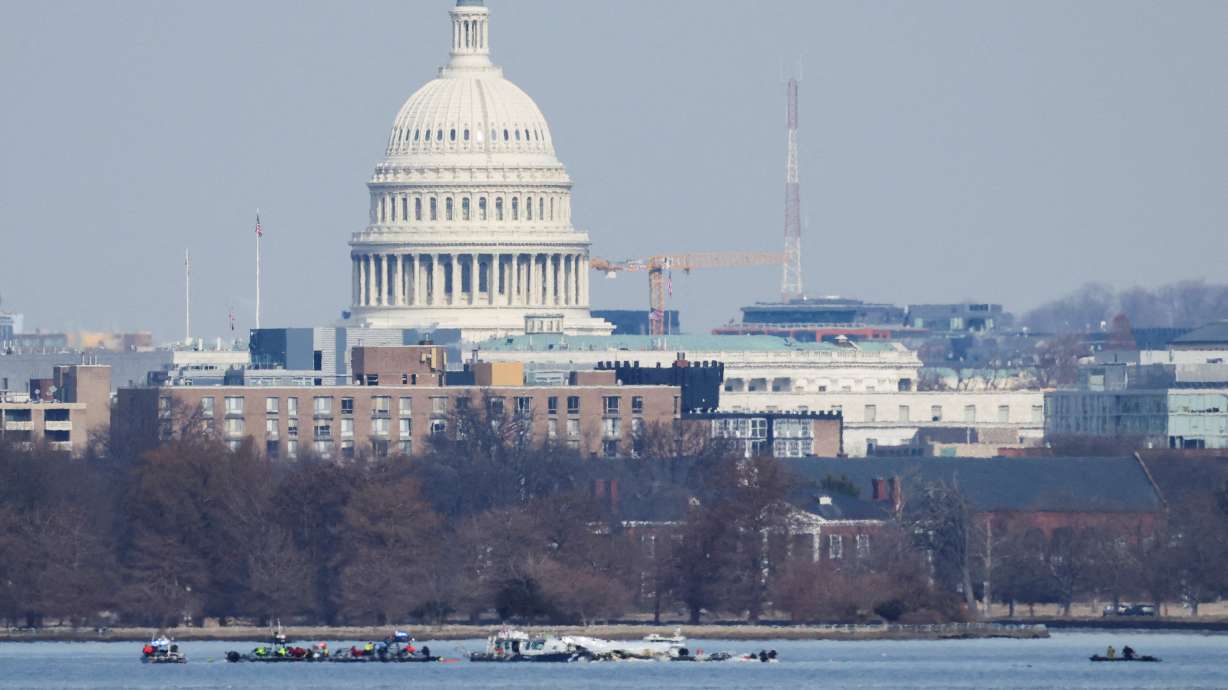 Search and rescue teams work in the aftermath of the collision of American Eagle flight 5342 and a Black Hawk helicopter that crashed into the Potomac River, with the Capitol dome in the background, as seen from Virginia, Thursday.