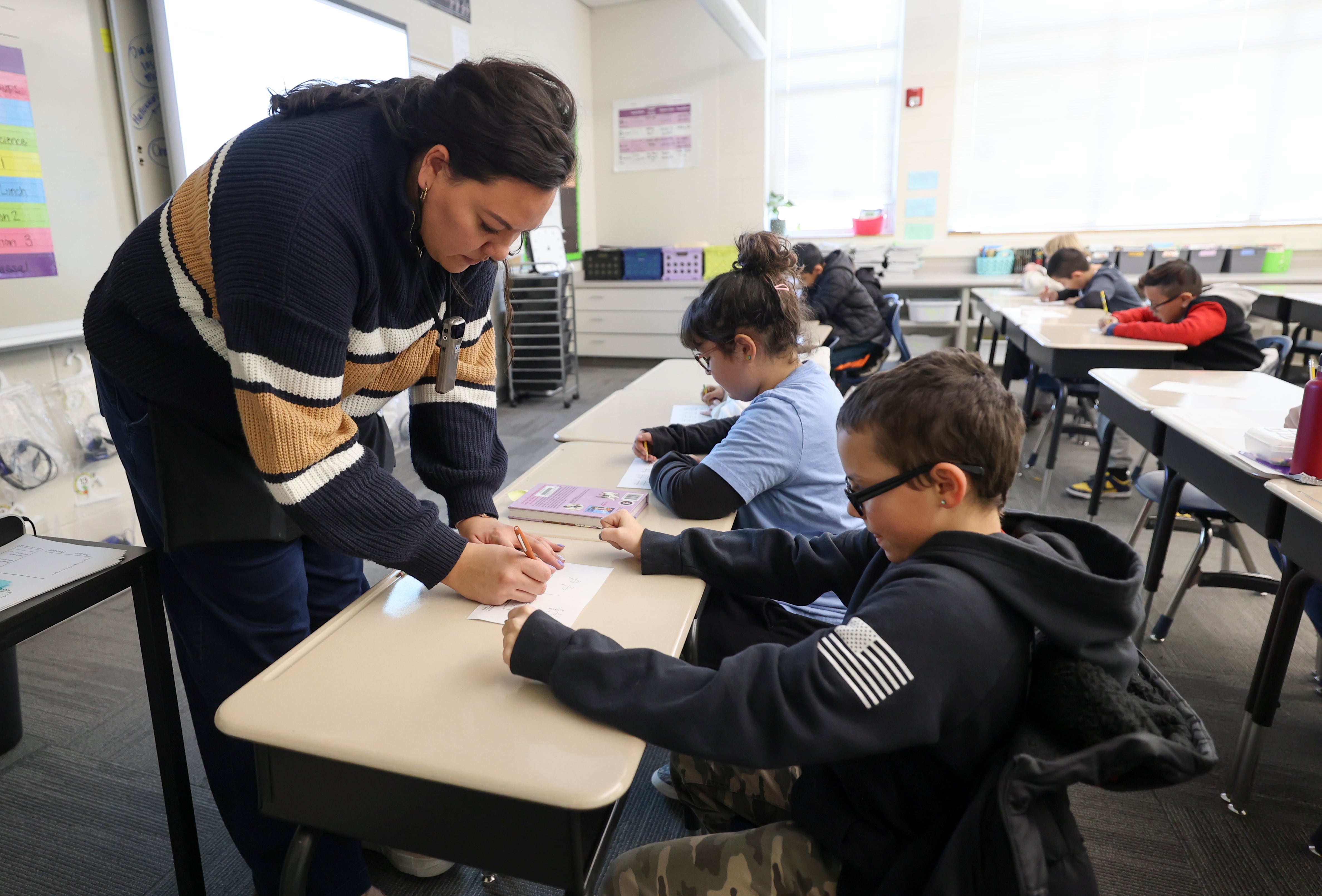 Fourth grade teacher Brianna Rolf helps Jeysen Dutton with math at Whittier Elementary School in Salt Lake City on Thursday.