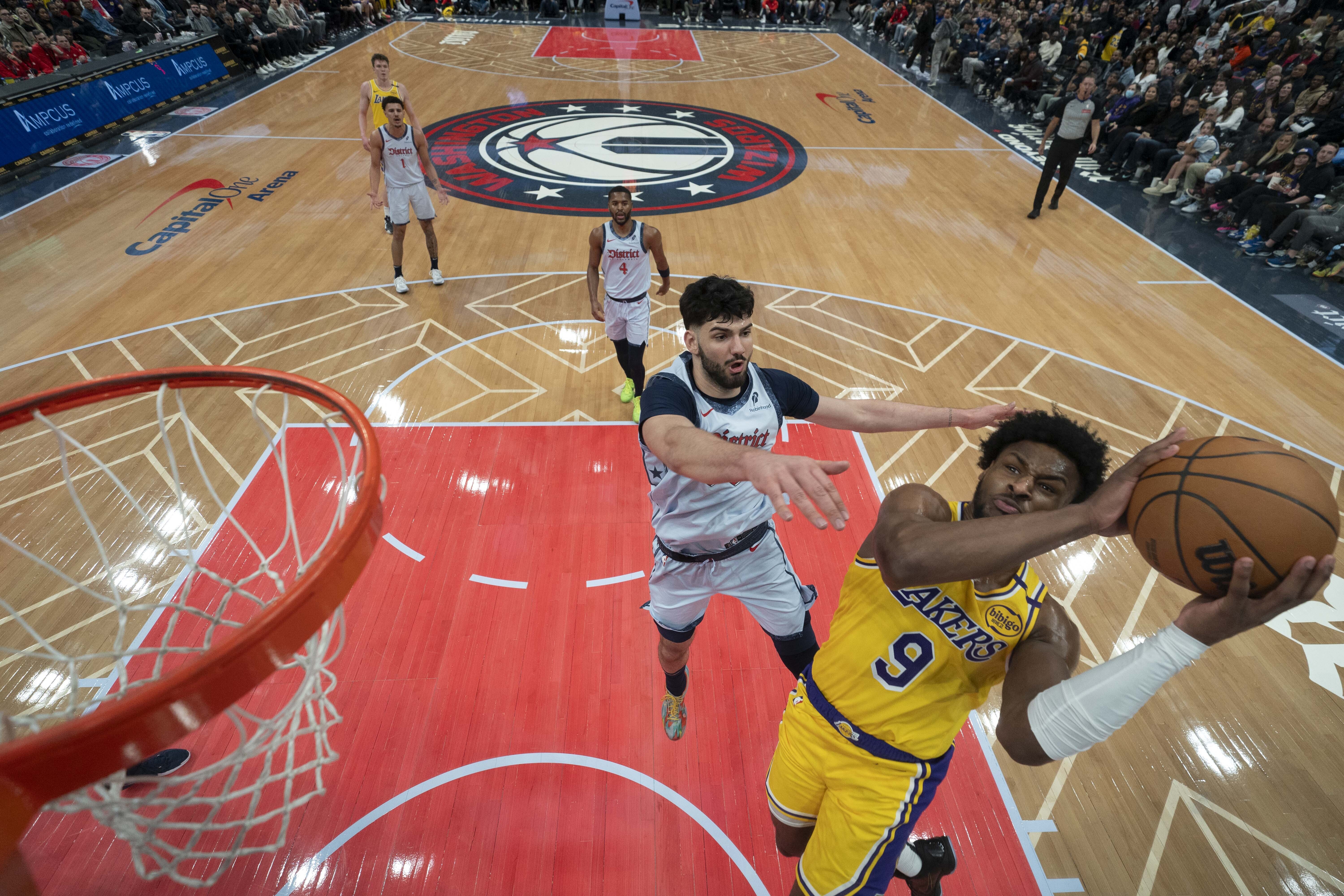Los Angeles Lakers guard Bronny James (9) goes up to shoot against Washington Wizards forward Tristan Vukcevic, second from front, during the second half of an NBA basketball game Thursday, Jan. 30, 2025, in Washington. 