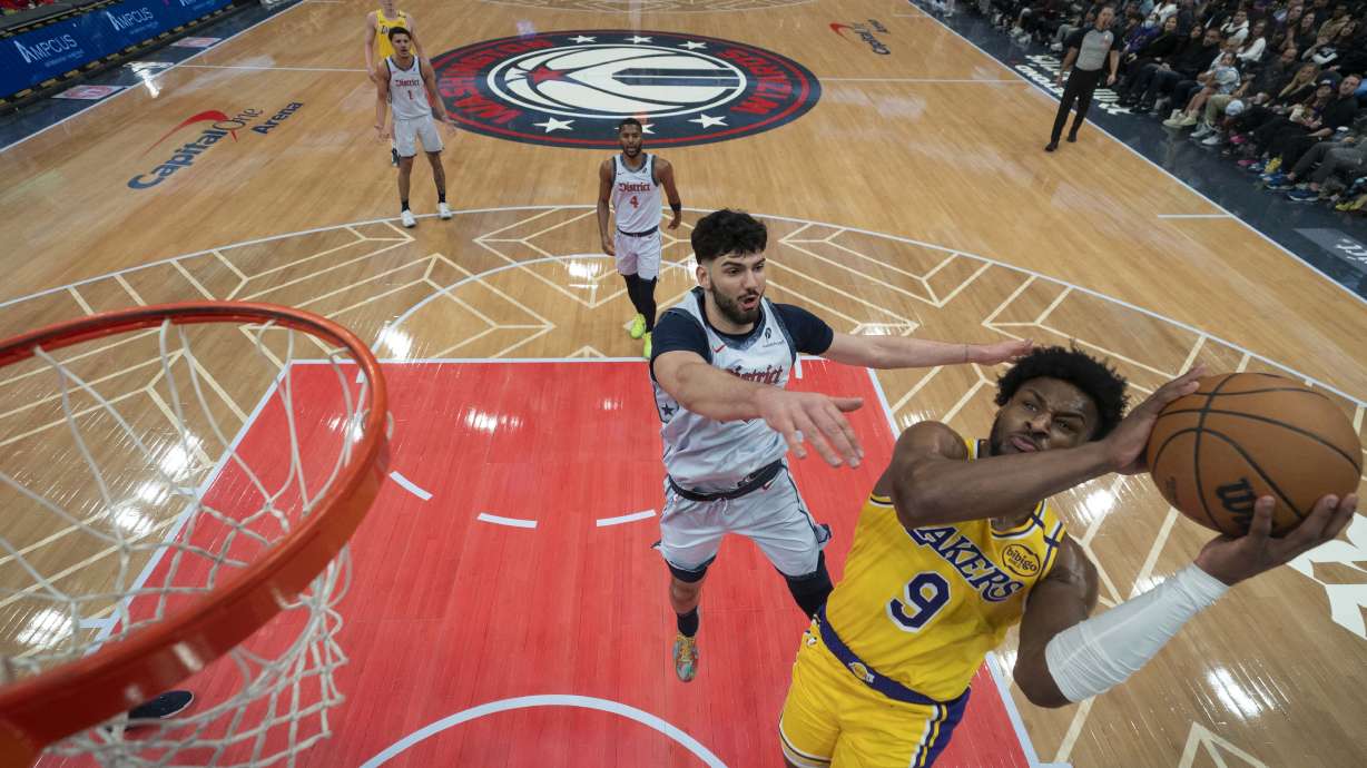 Los Angeles Lakers guard Bronny James (9) goes up to shoot against Washington Wizards forward Tristan Vukcevic, second from front, during the second half of an NBA basketball game Thursday, Jan. 30, 2025, in Washington.
