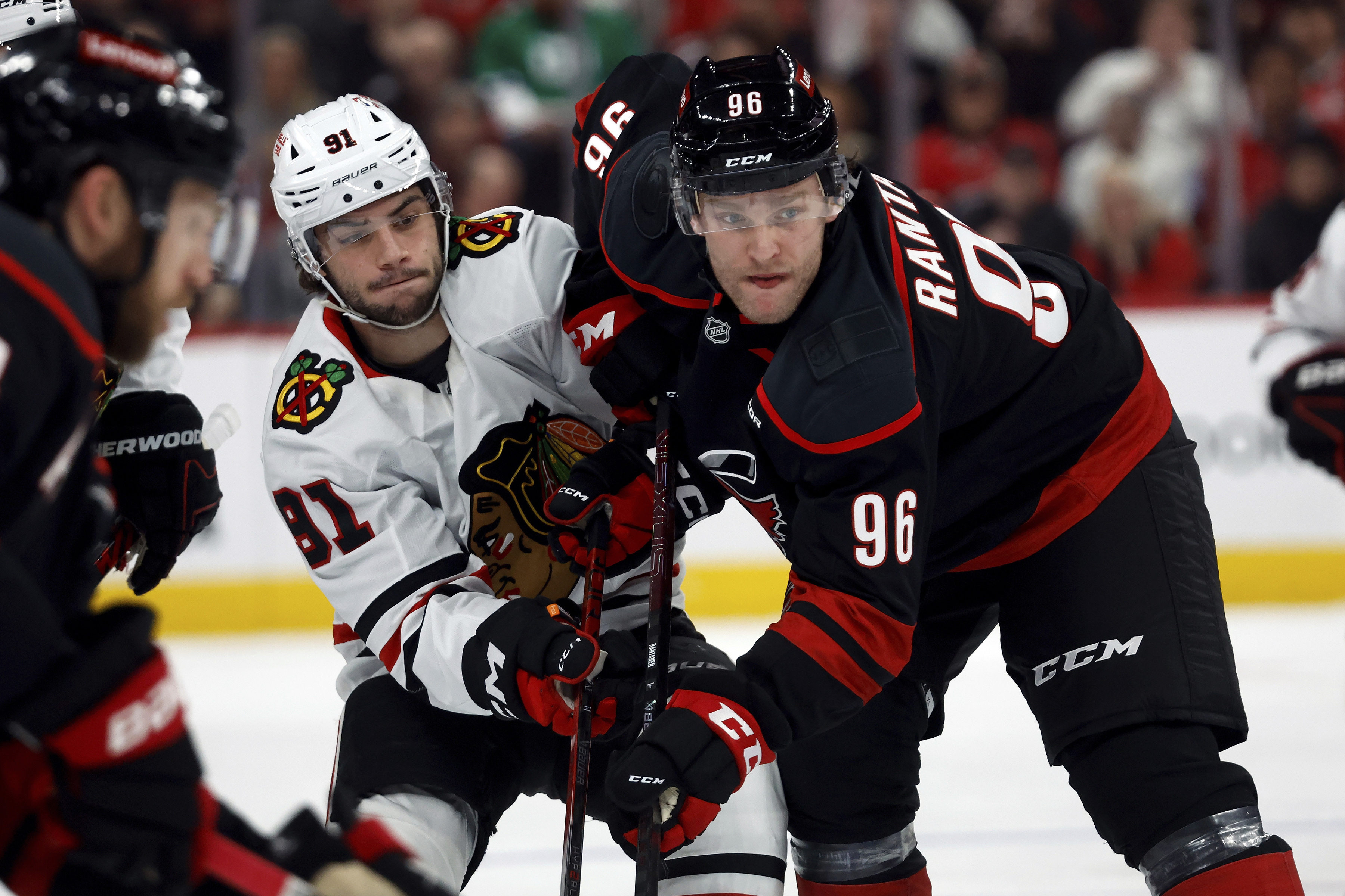 Carolina Hurricanes' Mikko Rantanen (96) battles with Chicago Blackhawks' Frank Nazar (91) following a face off during the first period of an NHL hockey game in Raleigh, N.C., Thursday, Jan. 30, 2025. 
