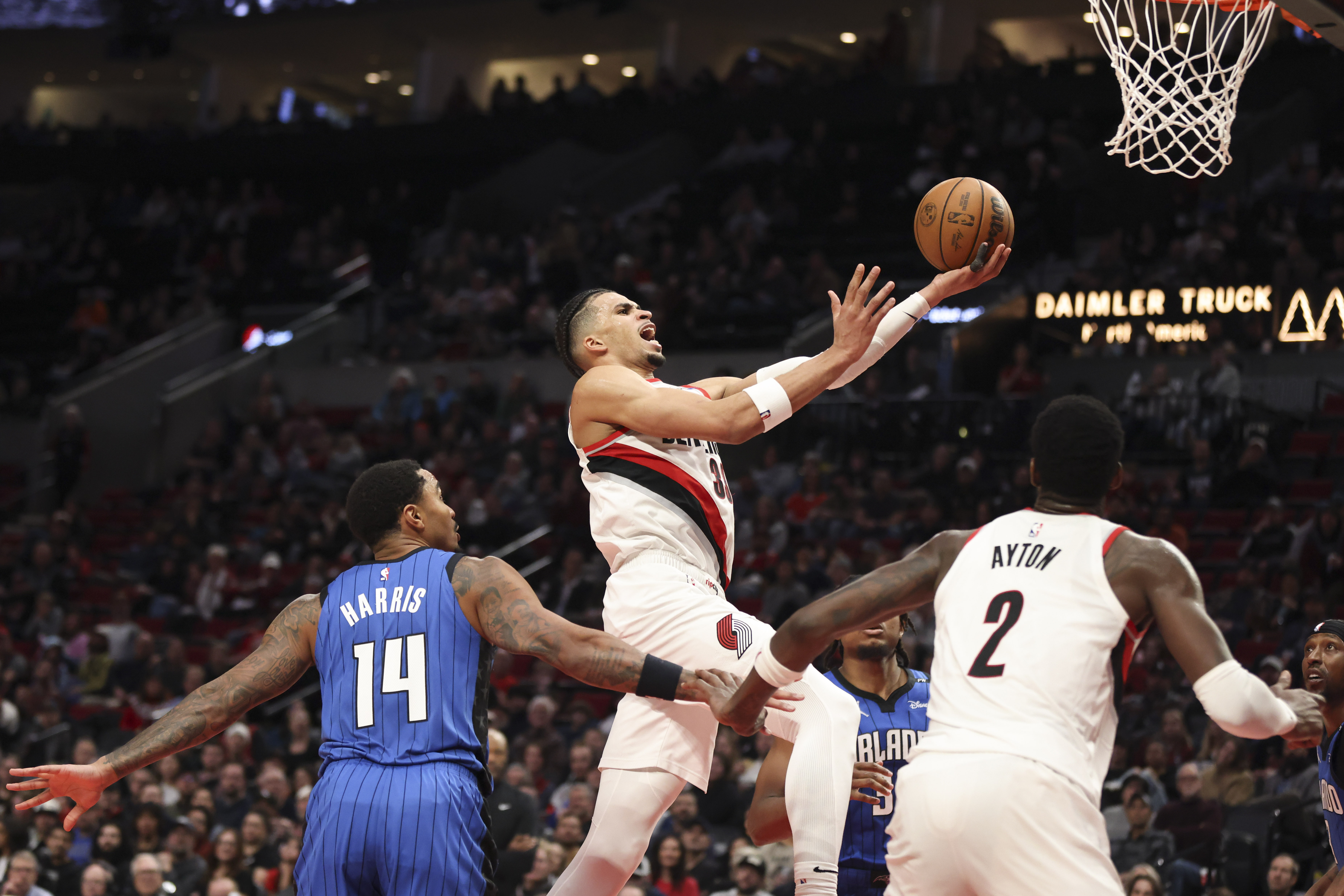 Portland Trail Blazers forward Toumani Camara (33) drives past Orlando Magic guard Gary Harris (14) to the basket during the second half of an NBA basketball game Thursday, Jan. 30, 2025, in Portland, Ore. 