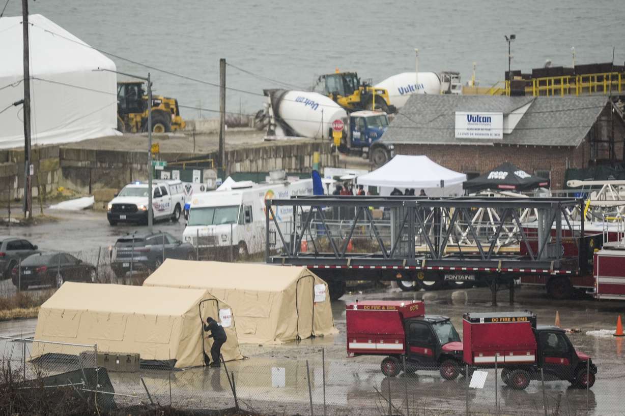 Emergency vehicles and recovery operations are seen near the mouth of the Anacostia River at the Potomac River near Ronald Reagan Washington National Airport, Friday, in Washington.