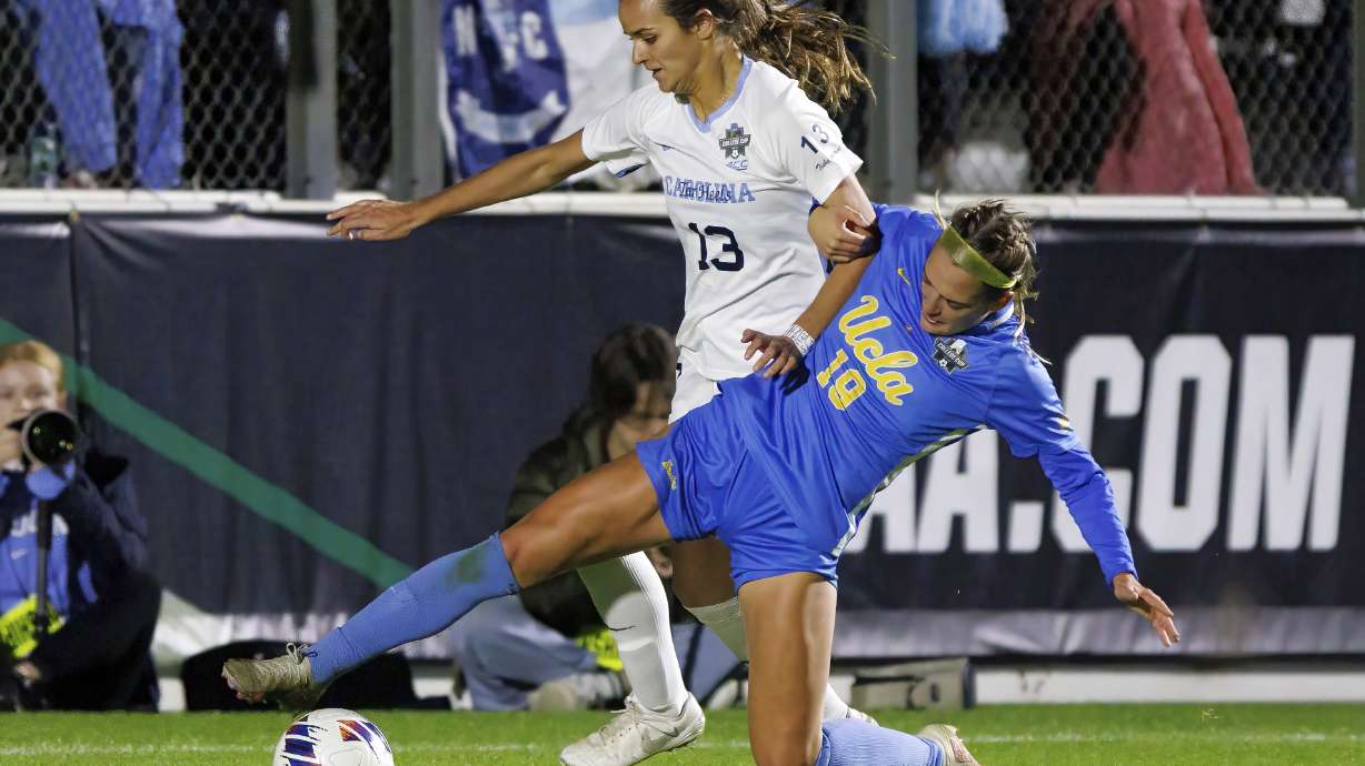 FILE - North Carolina's Isabel Coxs (13) and UCLA's Quincy McMahon (19) battle for a ball during the second half of the NCAA women's soccer tournament final in Cary, N.C., Monday, Dec. 5, 2022.