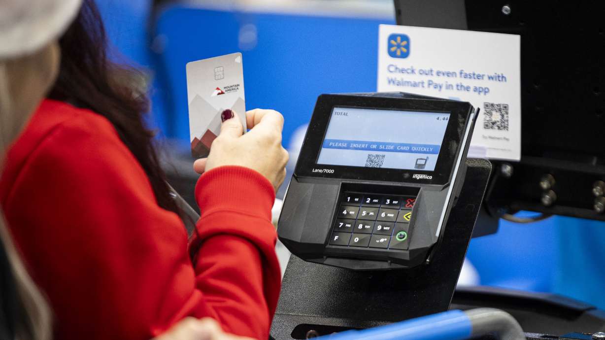 A shopper pays with a credit card at the South Jordan Parkway Walmart on Saturday, Dec. 7, 2024.
