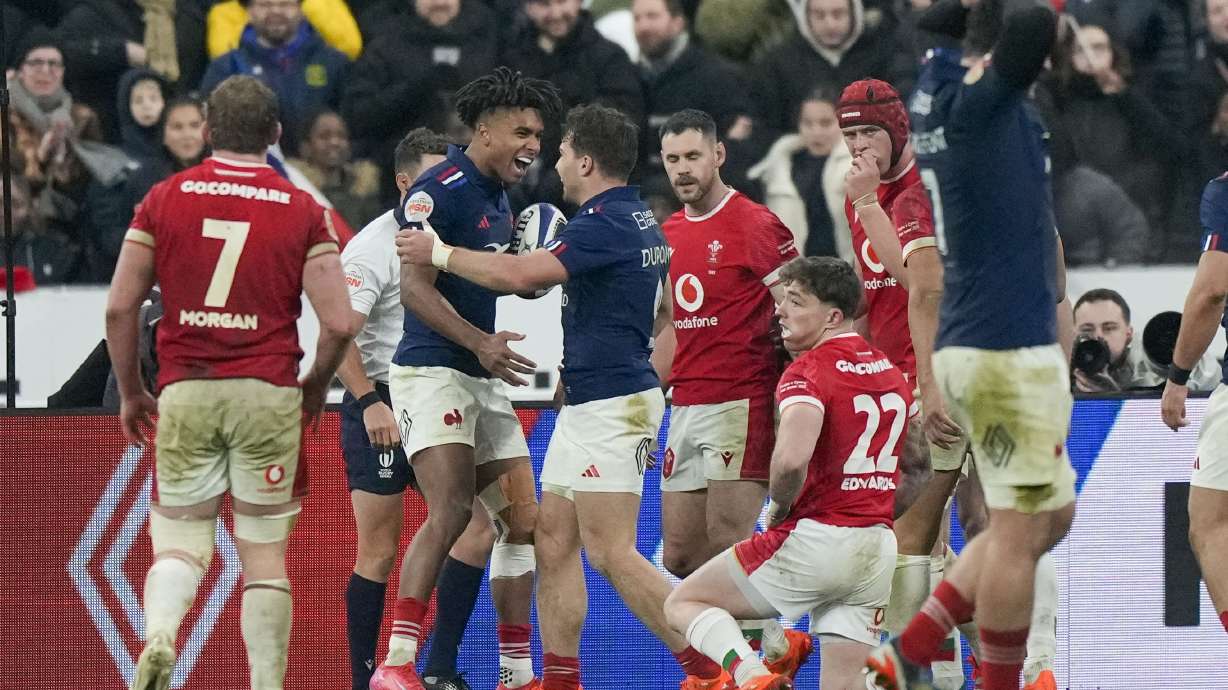 France's Theo Attissogbe, second left, celebrates with Antoine Dupont after scoring a try during the Six Nations rugby union match between France and Wales at the Stade de France in Saint-Denis, outside Paris, Friday, Jan. 31, 2025.