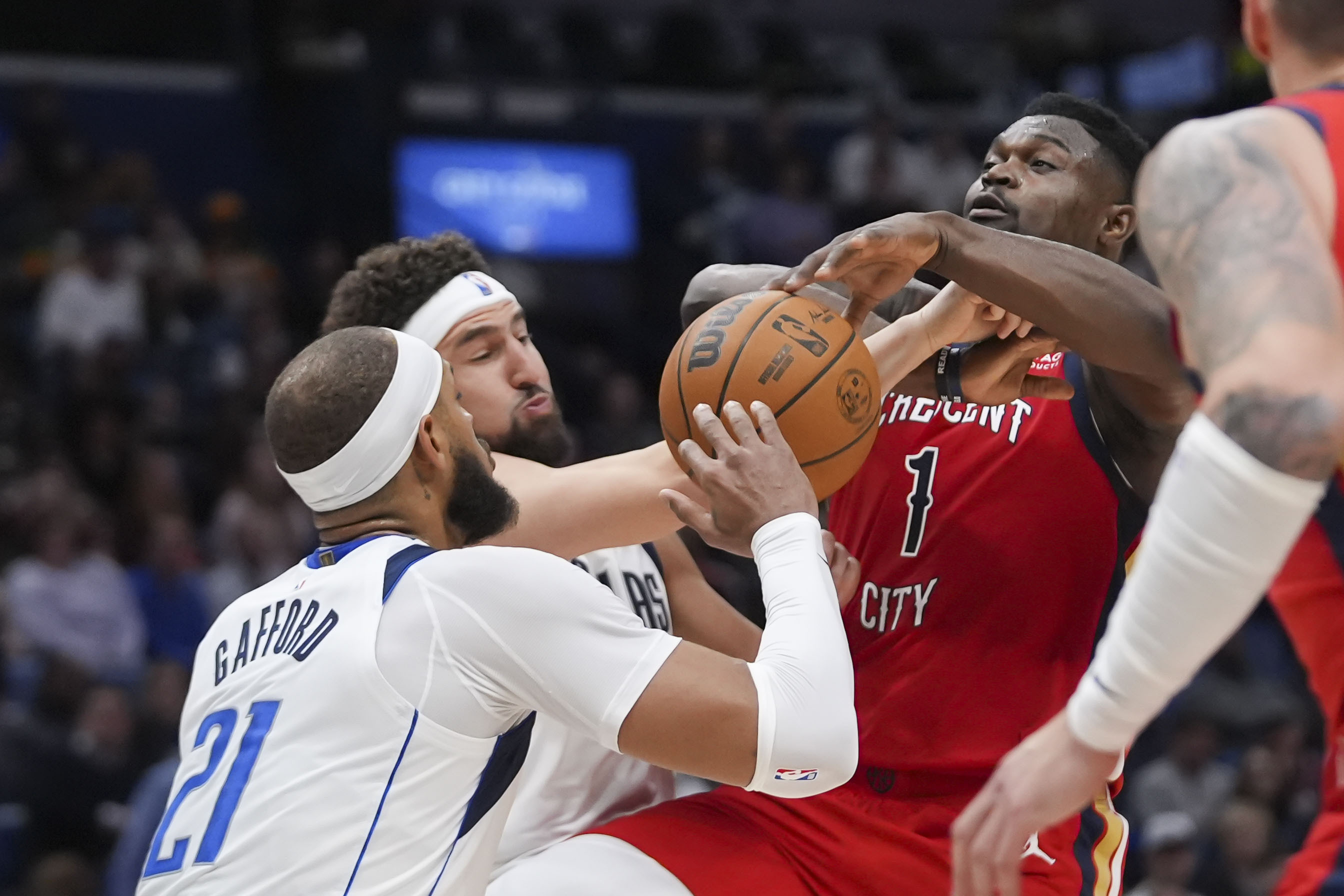 New Orleans Pelicans forward Zion Williamson (1) is fouled as he drives to the basket against Dallas Mavericks center Daniel Gafford (21) and guard Klay Thompson in the first half of an NBA basketball game in New Orleans, Wednesday, Jan. 29, 2025. 