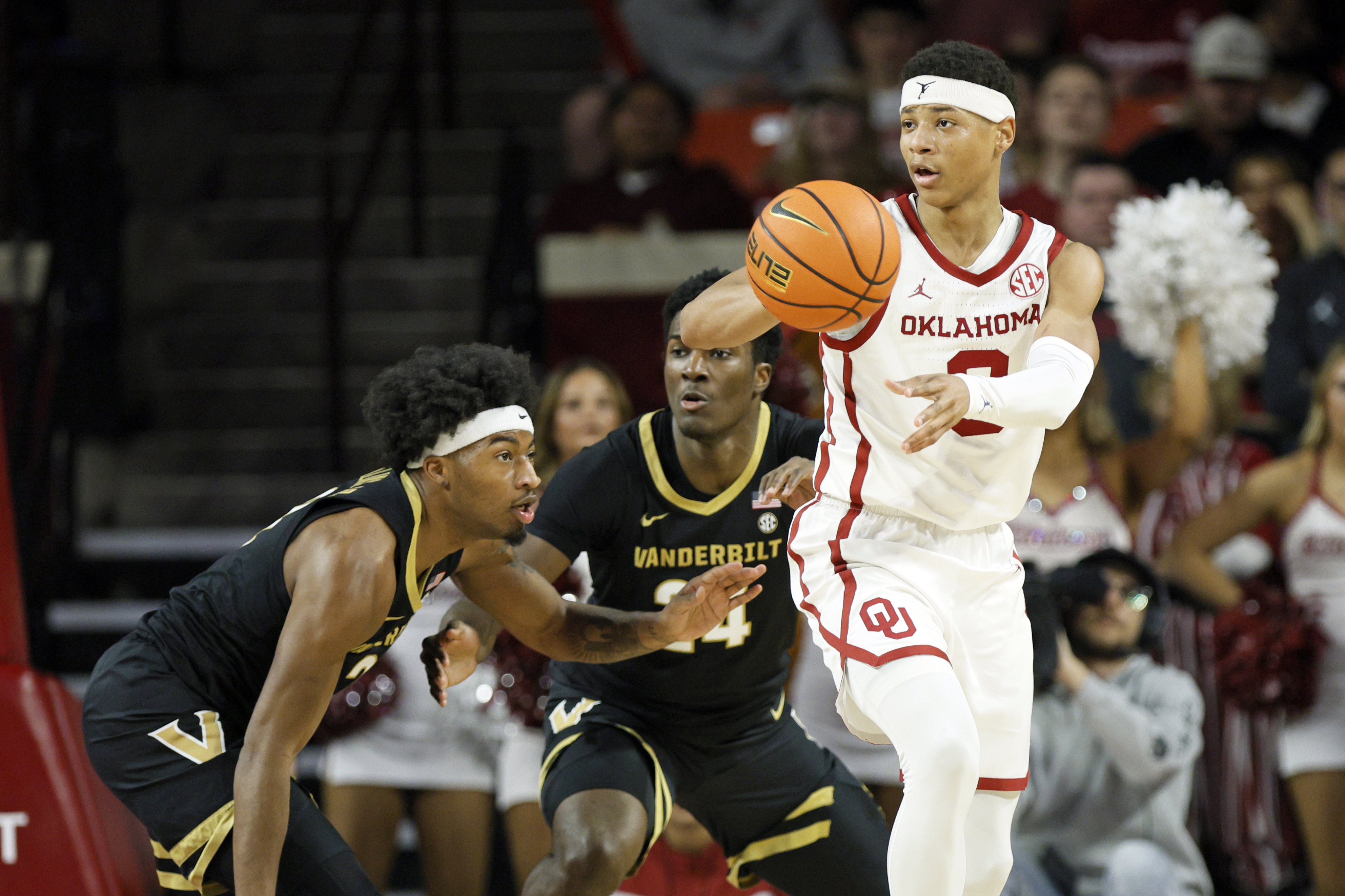 Oklahoma guard Jeremiah Fears, right, passes the ball away from Vanderbilt guard MJ Collins Jr., left, and forward JaQualon Roberts, center, during the first half of an NCAA college basketball game Saturday, Feb. 1, 2025, in Norman, Okla. 