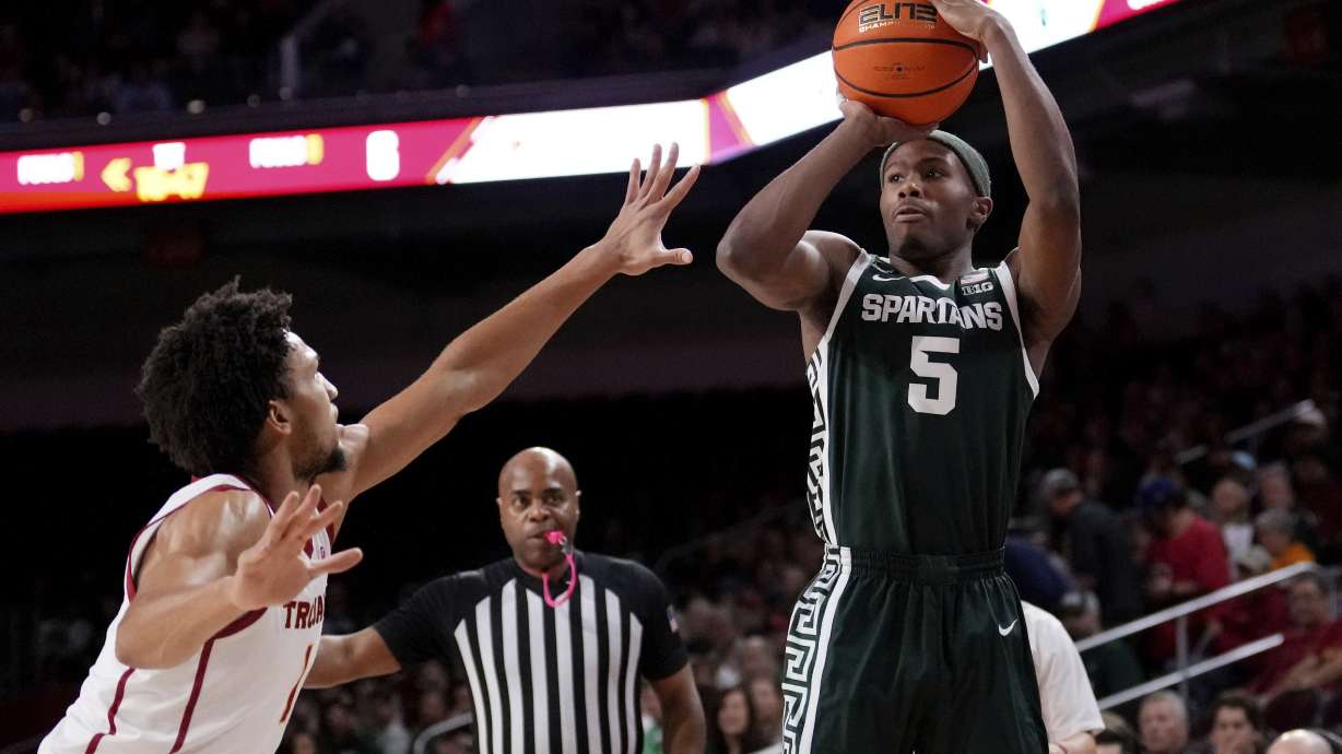 Michigan State guard Tre Holloman, right, shoots as Southern California guard Desmond Claude defends during the first half of an NCAA college basketball game, Saturday, Feb. 1, 2025, in Los Angeles.