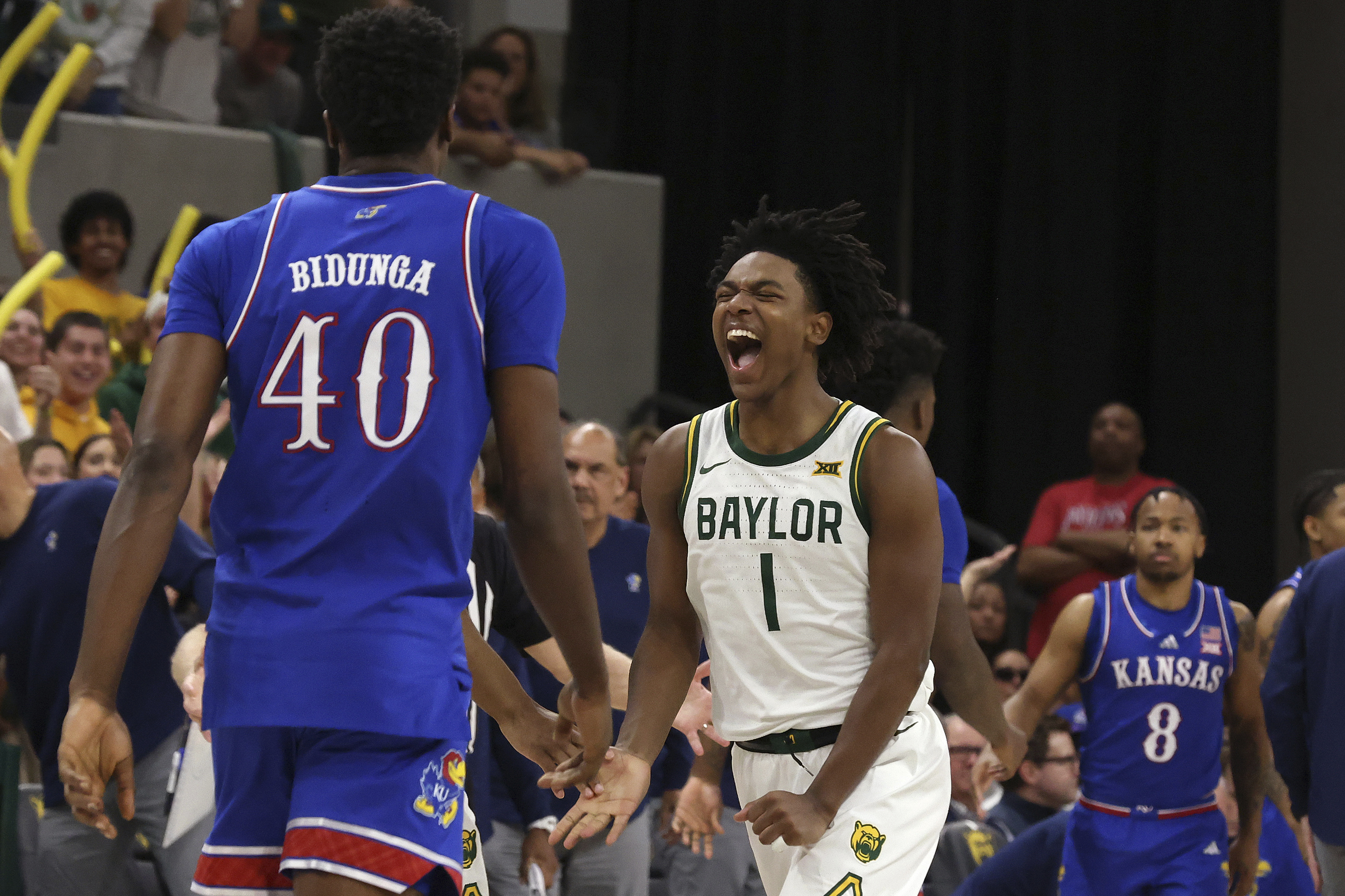 Baylor guard Robert Wright III celebrates after scoring as Kansas forward Flory Bidunga walks back to the bench while his teammate, guard David Coit, looks on during the second half of an NCAA college basketball game Saturday, Feb. 1, 2025, in Waco, Texas. 