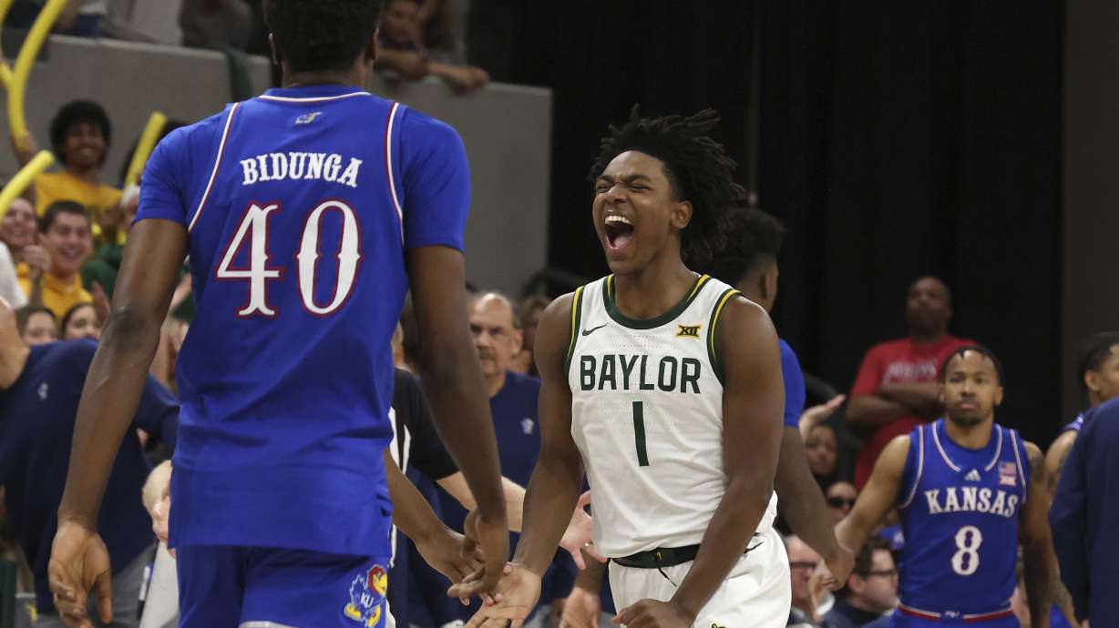 Baylor guard Robert Wright III celebrates after scoring as Kansas forward Flory Bidunga walks back to the bench while his teammate, guard David Coit, looks on during the second half of an NCAA college basketball game Saturday, Feb. 1, 2025, in Waco, Texas.