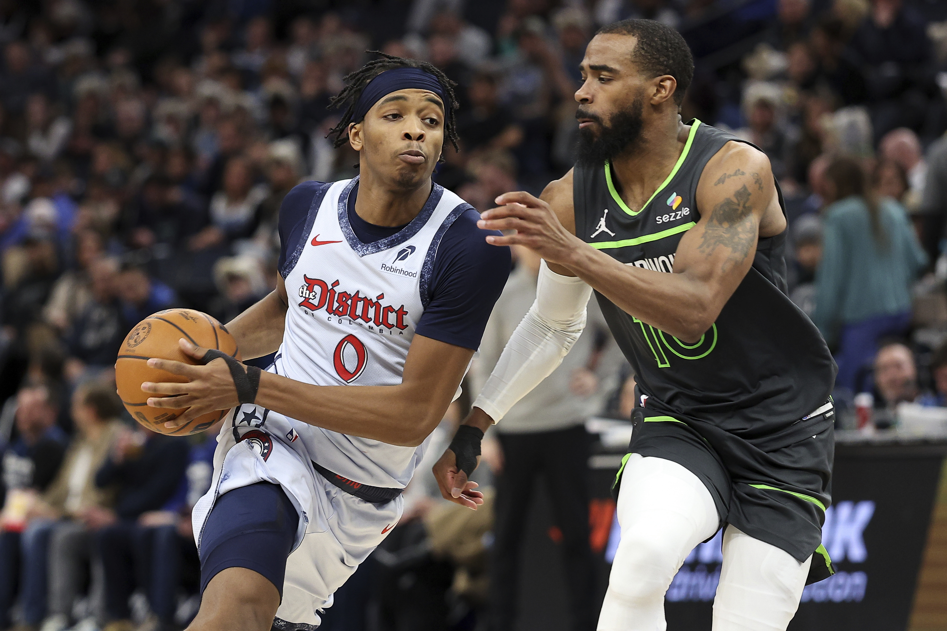 Washington Wizards guard Bilal Coulibaly, left, work around Minnesota Timberwolves guard Mike Conley during the second half of an NBA basketball game Saturday, Feb. 1, 2025, in Minneapolis. 