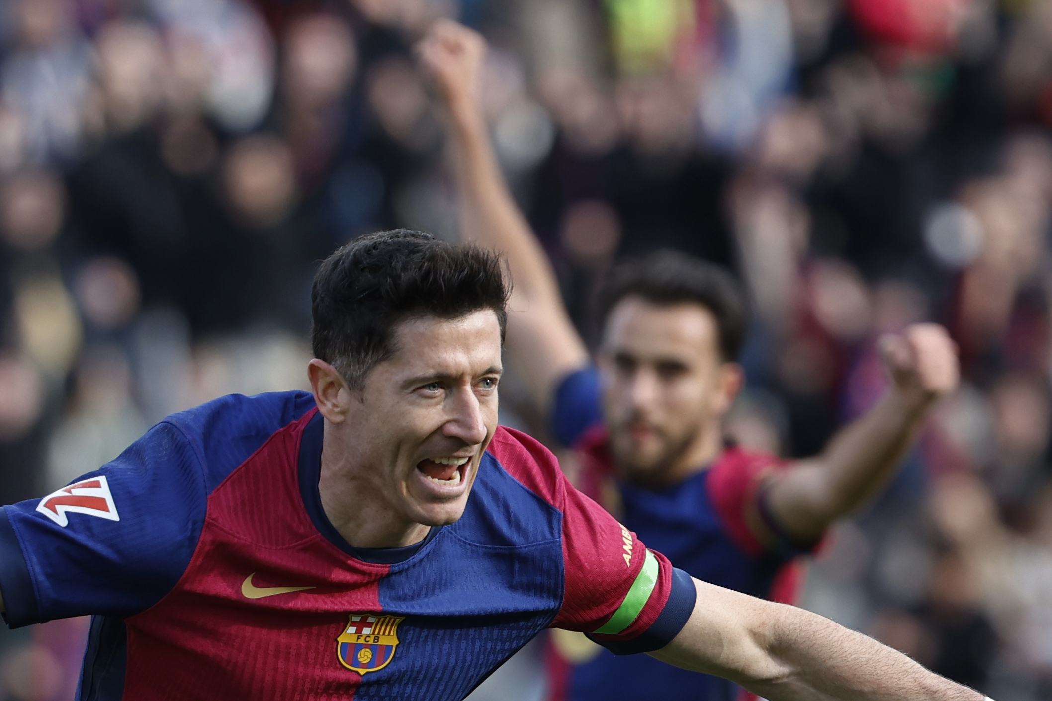 Barcelona's Robert Lewandowski, left, celebrates after scoring the opening goal during a Spanish La Liga soccer match between Barcelona and Alaves at the Lluis Companys Olympic Stadium in Barcelona, Spain, Sunday Feb. 2, 2025. 