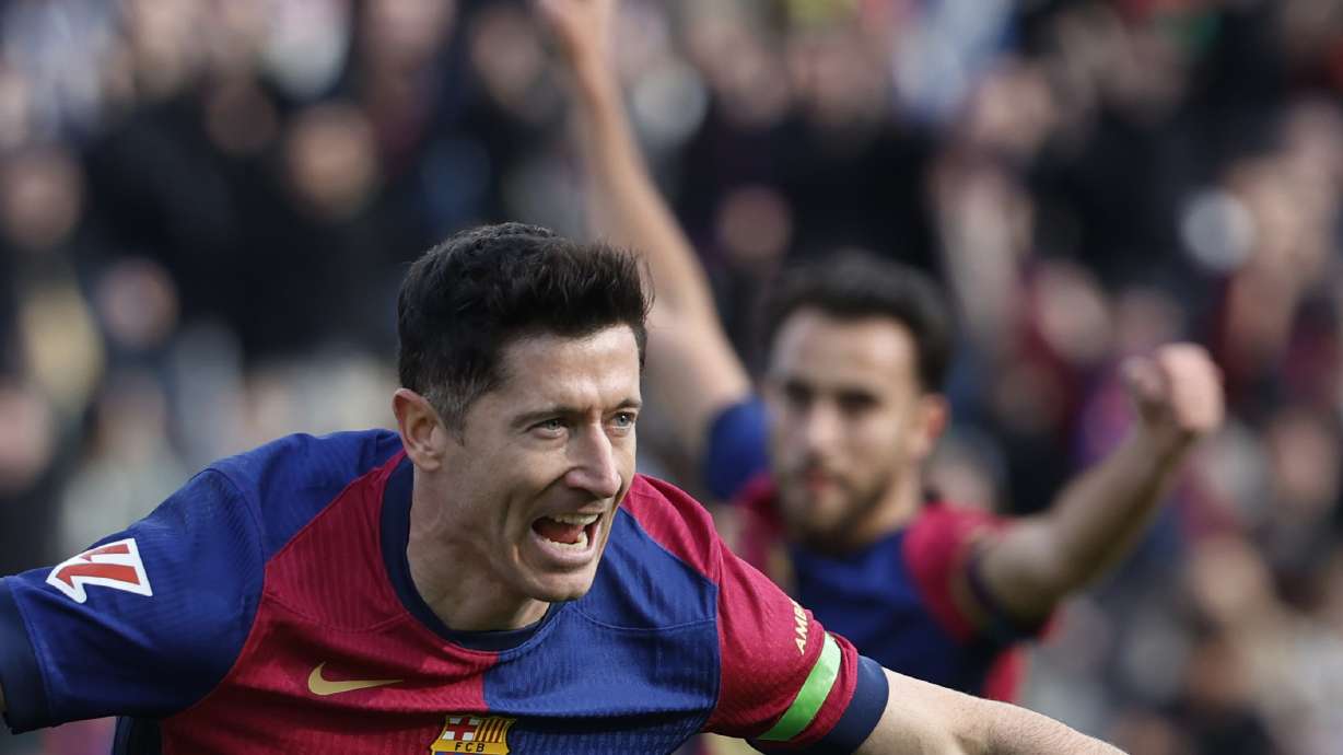 Barcelona's Robert Lewandowski, left, celebrates after scoring the opening goal during a Spanish La Liga soccer match between Barcelona and Alaves at the Lluis Companys Olympic Stadium in Barcelona, Spain, Sunday Feb. 2, 2025.