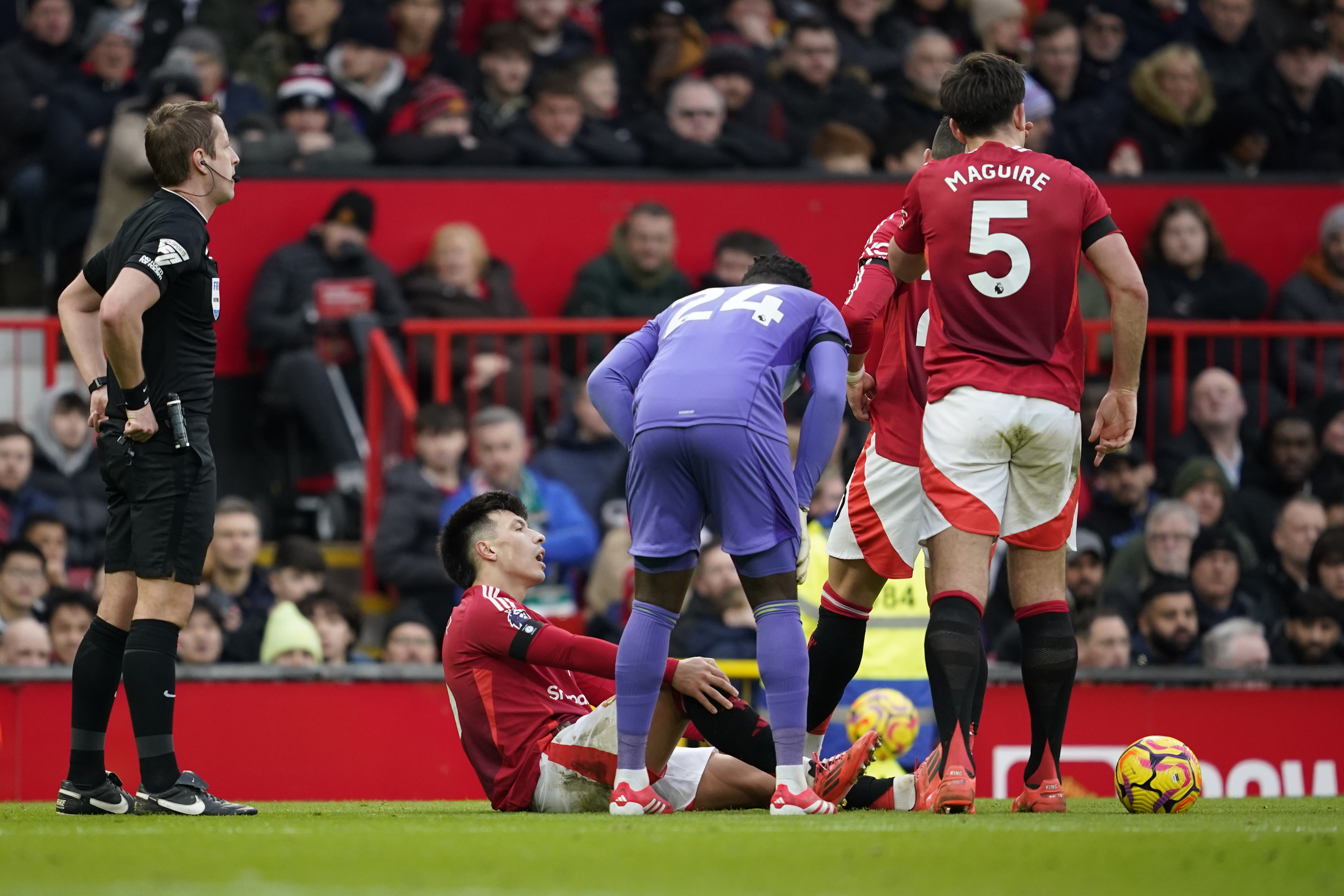 Manchester United's Lisandro Martinez holds his knee after an injury during the English Premier League soccer match between Manchester United and Crystal Palace at Old Trafford stadium in Manchester, England, Sunday, Feb. 2, 2025. 
