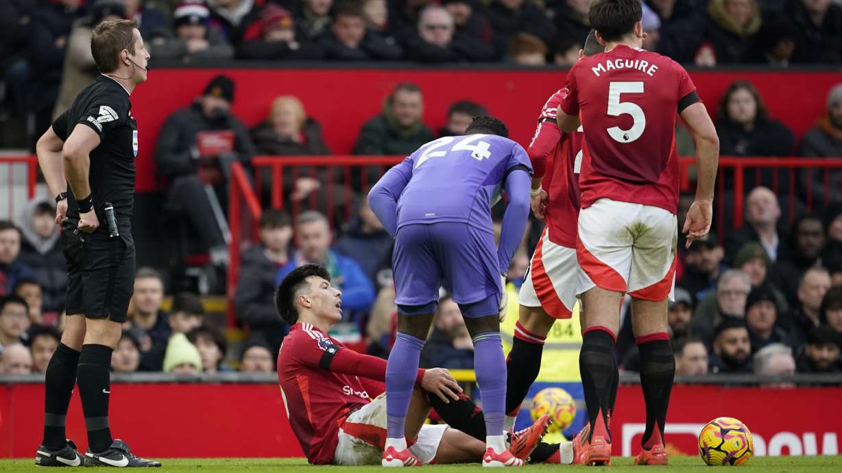 Manchester United's Lisandro Martinez holds his knee after an injury during the English Premier League soccer match between Manchester United and Crystal Palace at Old Trafford stadium in Manchester, England, Sunday, Feb. 2, 2025.