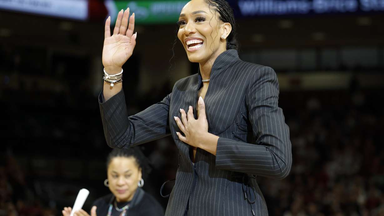 A'ja Wilson, center, stands with her parents Eva and Roscoe Wilson as they watch her number be retired during a ceremony before an NCAA college basketball game between South Carolina and Auburn in Columbia, S.C., Sunday, Feb. 2, 2025.