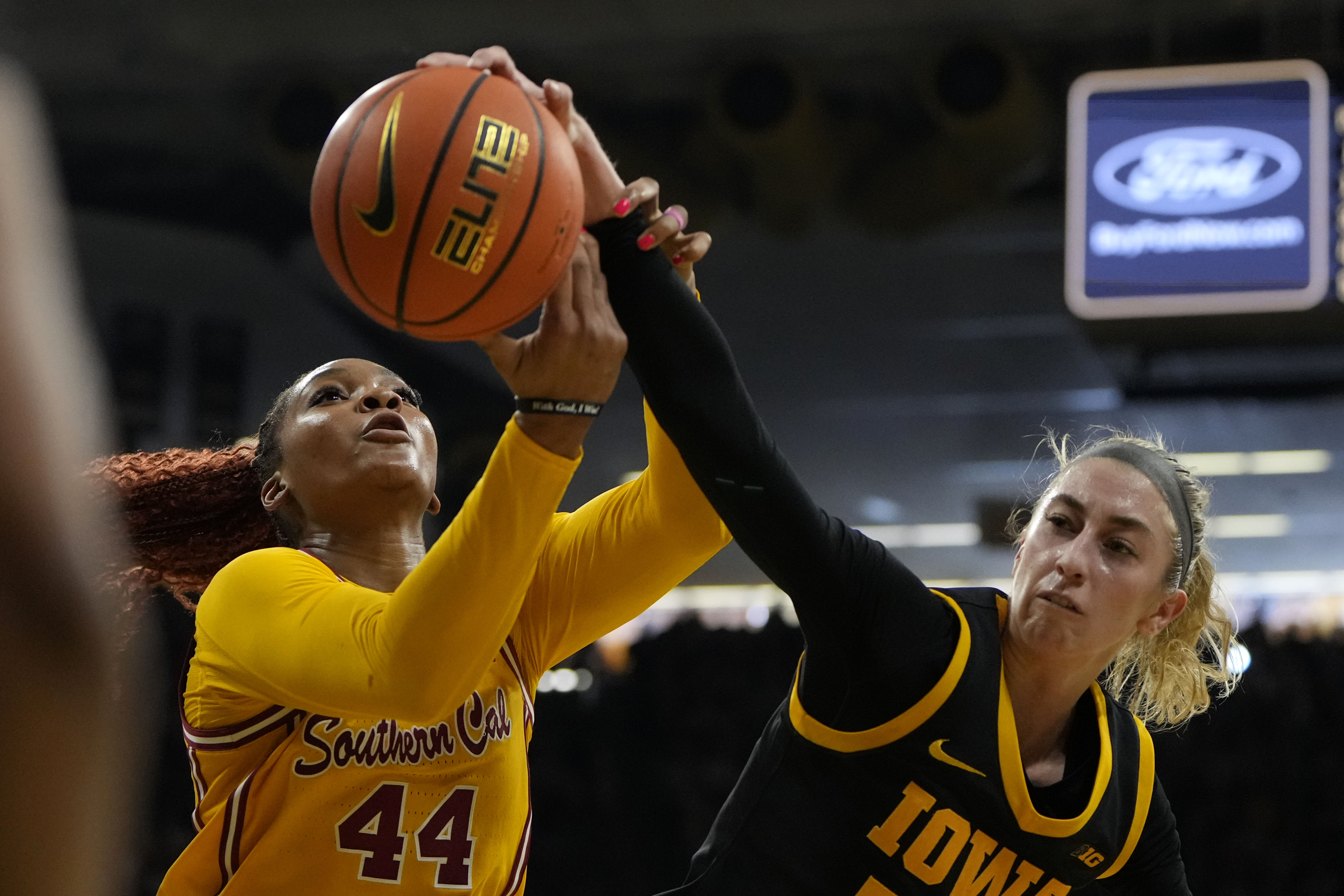 Southern California forward Kiki Iriafen (44) fights for a rebound with Iowa guard Lucy Olsen, right, during the first half of an NCAA college basketball game, Sunday, Feb. 2, 2025, in Iowa City, Iowa. 