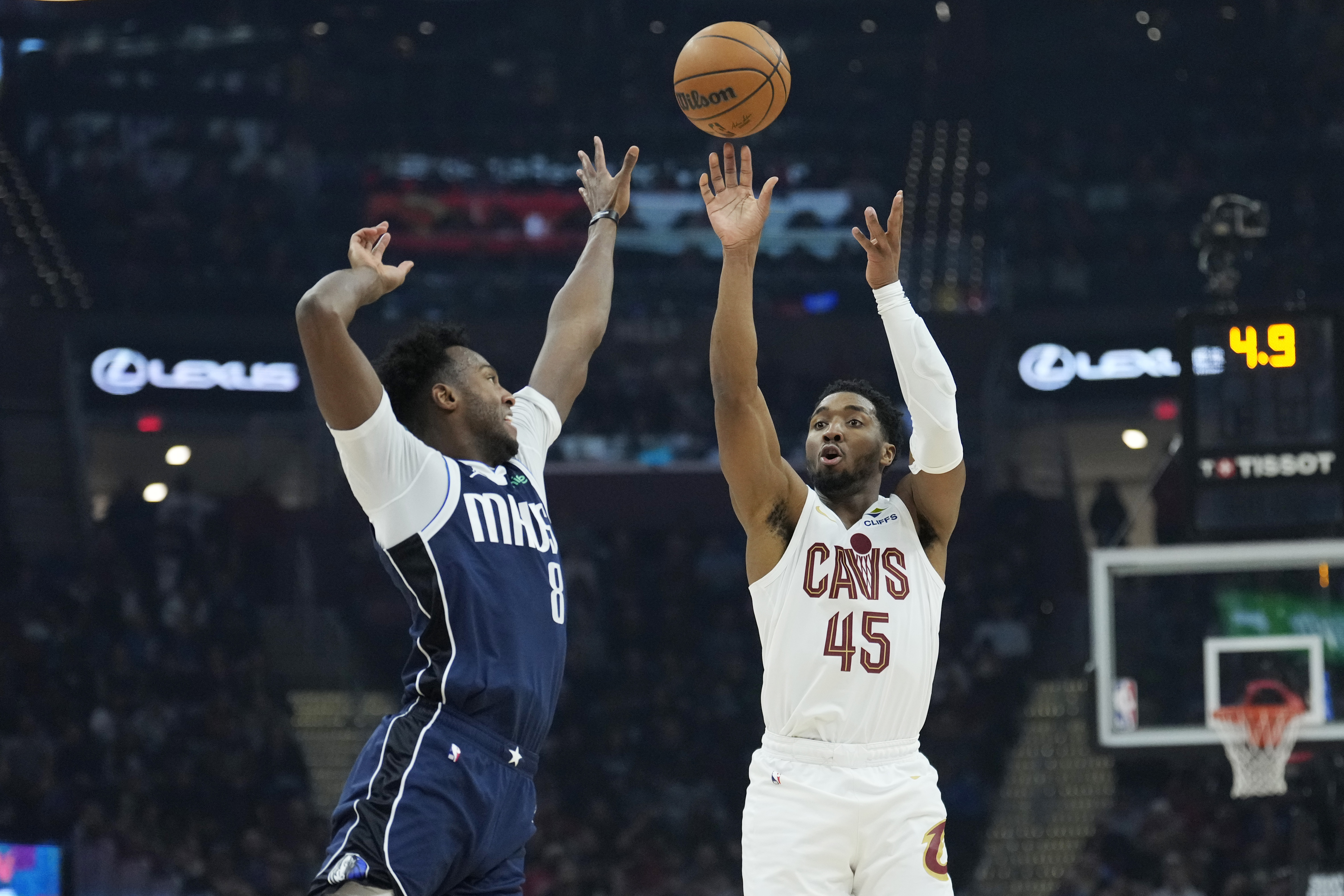 Cleveland Cavaliers guard Donovan Mitchell (45) shoots a 3-point basket over Dallas Mavericks forward Olivier-Maxence Prosper (8) in the first half of an NBA basketball game, Sunday, Feb. 2, 2025, in Cleveland. 