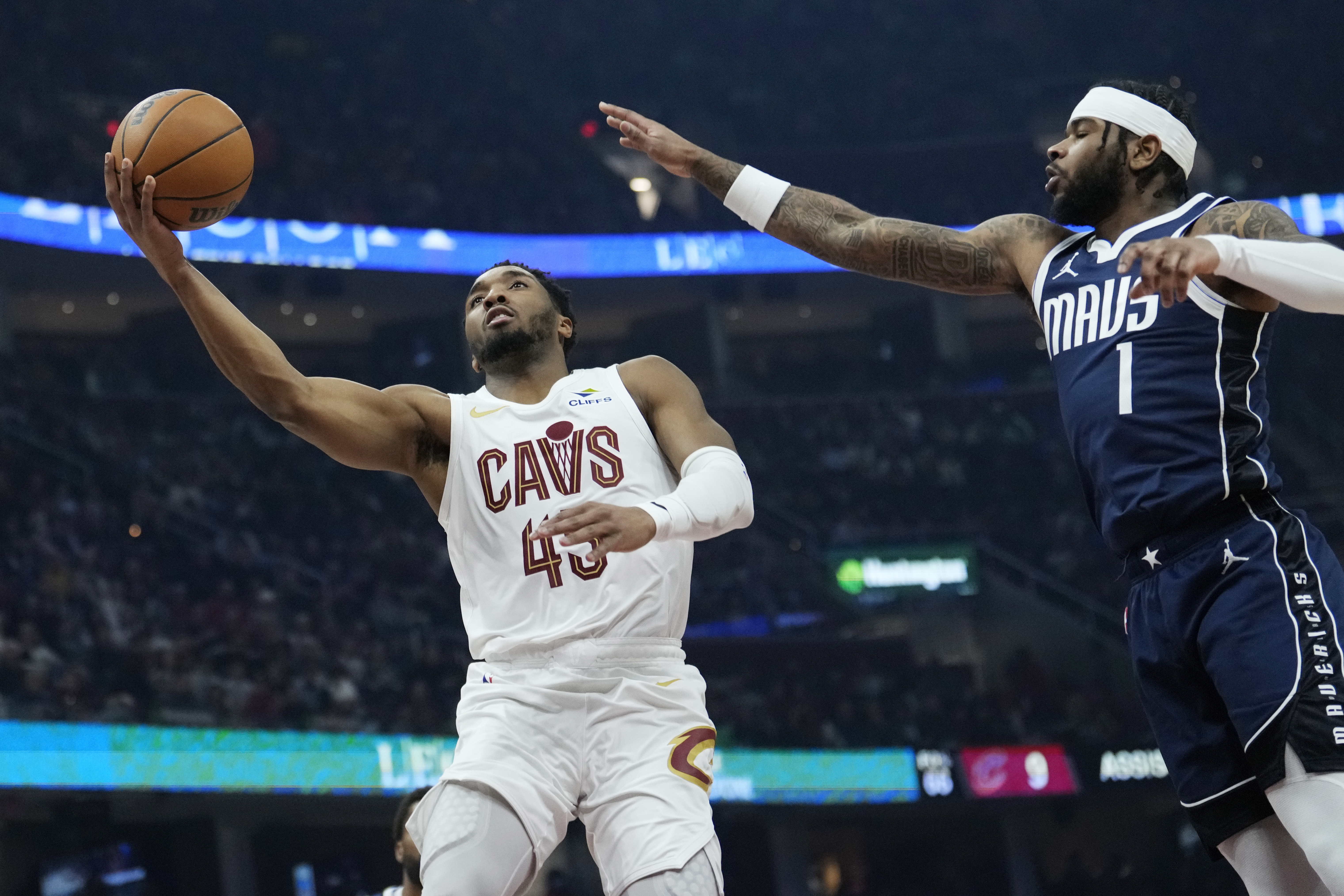Cleveland Cavaliers guard Donovan Mitchell (45) goes to the basket next to Dallas Mavericks guard Jaden Hardy (1) in the first half of an NBA basketball game, Sunday, Feb. 2, 2025, in Cleveland.