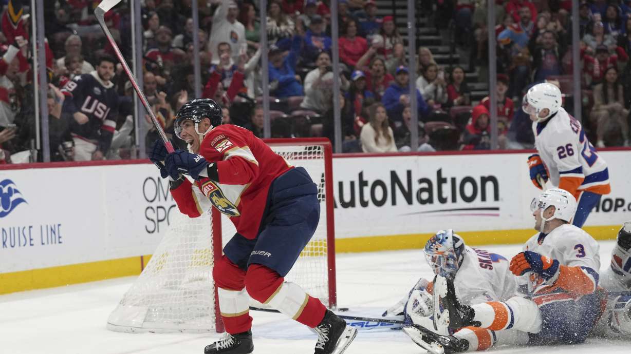 Florida Panthers center Evan Rodrigues, left, reacts after scoring against New York Islanders goalie Jakub Skarek (1) during the second period of an NHL hockey game, Sunday, Feb. 2, 2025, in Sunrise, Fla.