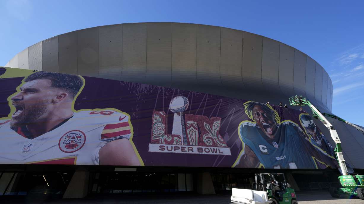Workers hang player banners outside the Caesars Superdome, Saturday, Feb. 1, 2025, in New Orleans, prior to the NFL Super Bowl 59 football game between the Philadelphia Eagles and the Kansas City Chiefs.